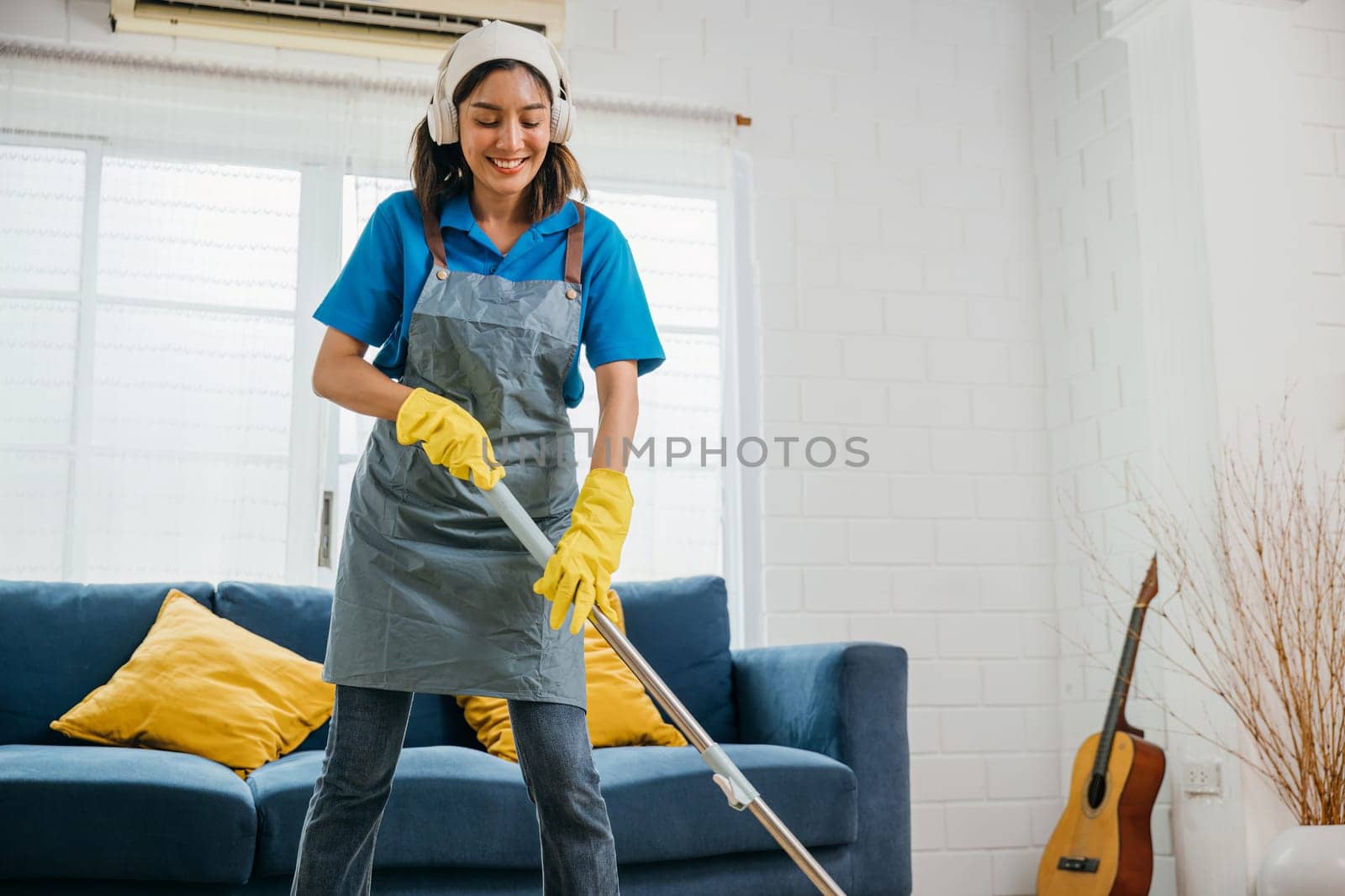 Asian teenager vibrant cleanup, maid sings dances in headphones. Joyful occupation blended with music excitement. Modern cleaning with tech appeal. Happy and Fun During Cleaning