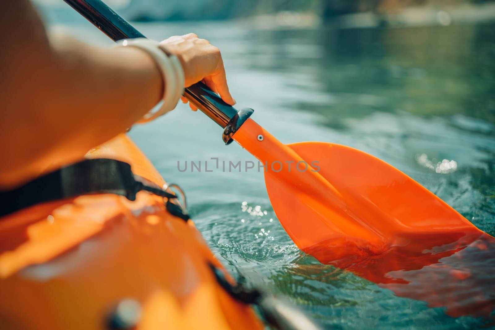 Kayak paddle sea vacation. Person paddles with orange paddle oar on kayak in sea. Leisure active lifestyle recreation activity rest tourism travel.