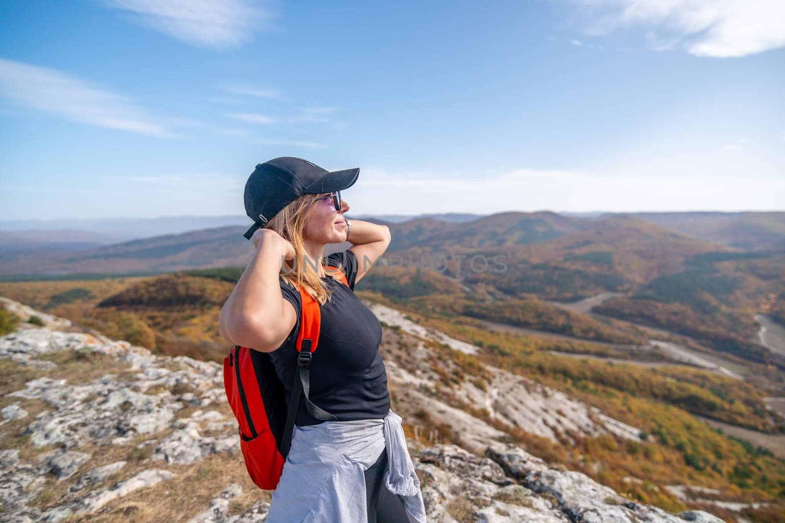 woman on mountain peak looking in beautiful mountain valley in autumn. Landscape with sporty young woman, blu sky in fall. Hiking. Nature by Matiunina