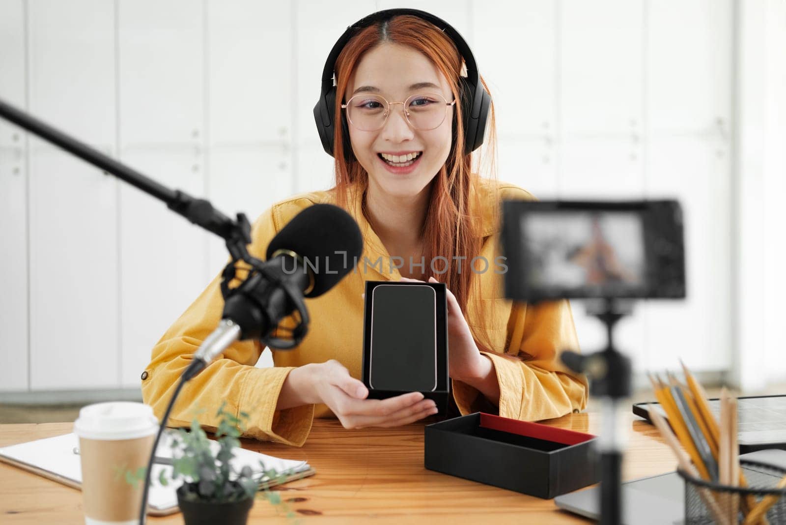 Female podcaster making audio podcast from her home studio by ijeab