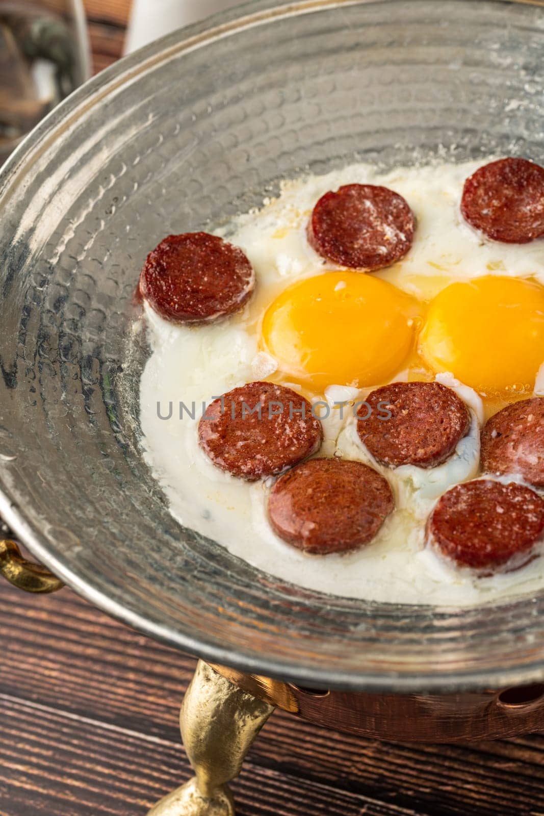 fried eggs with turkish sausage with bread and tea on wooden table