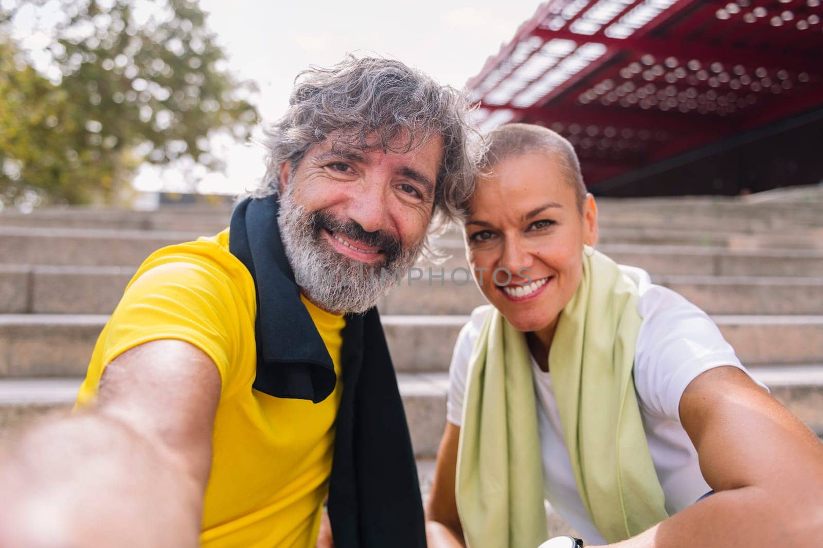 selfie photo of a smiling senior sports man with his personal trainer while they rest after training, concept of technology and healthy lifestyle