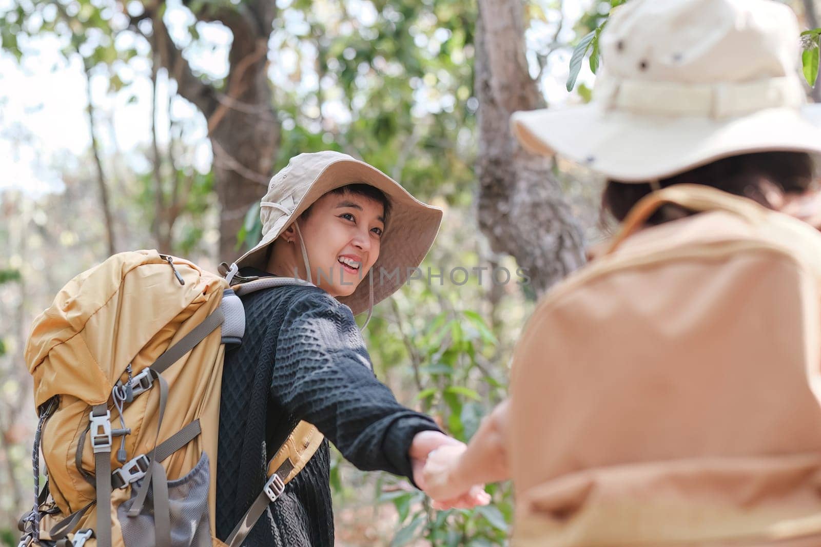 An Asian couple spends their free time on a hiking trip together..