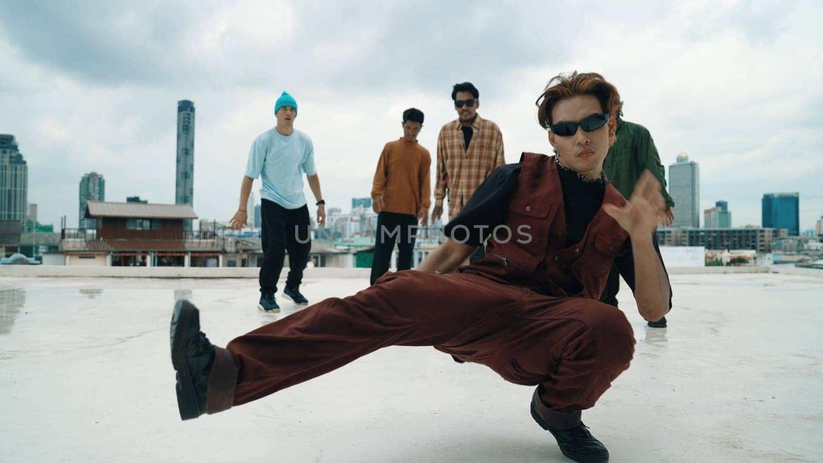 Professional asian street dancer practice B boy dance while multicultural friends at roof top. Young modern dancing group doing hip hop movement. Style,fashion,action. Outdoor sport 2024. Endeavor.