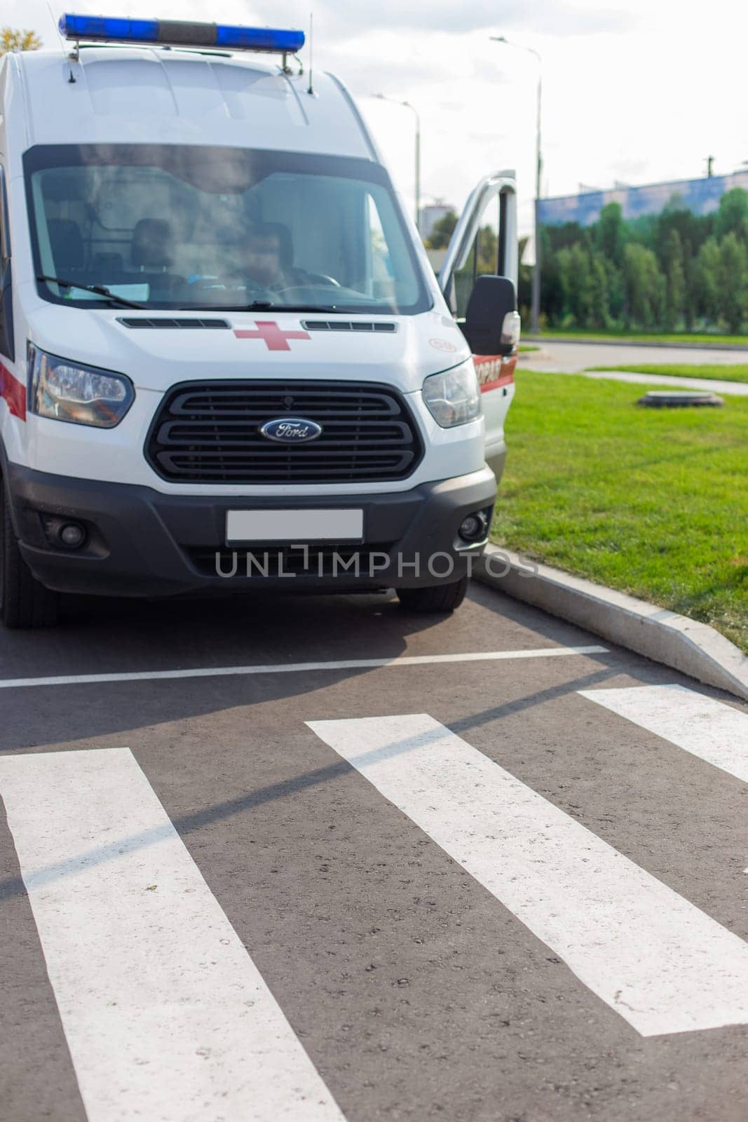 Moscow, Moscow region, Russia - 03.09.2023:Front view of a parked ambulance by a zebra crossing ready for emergency response.