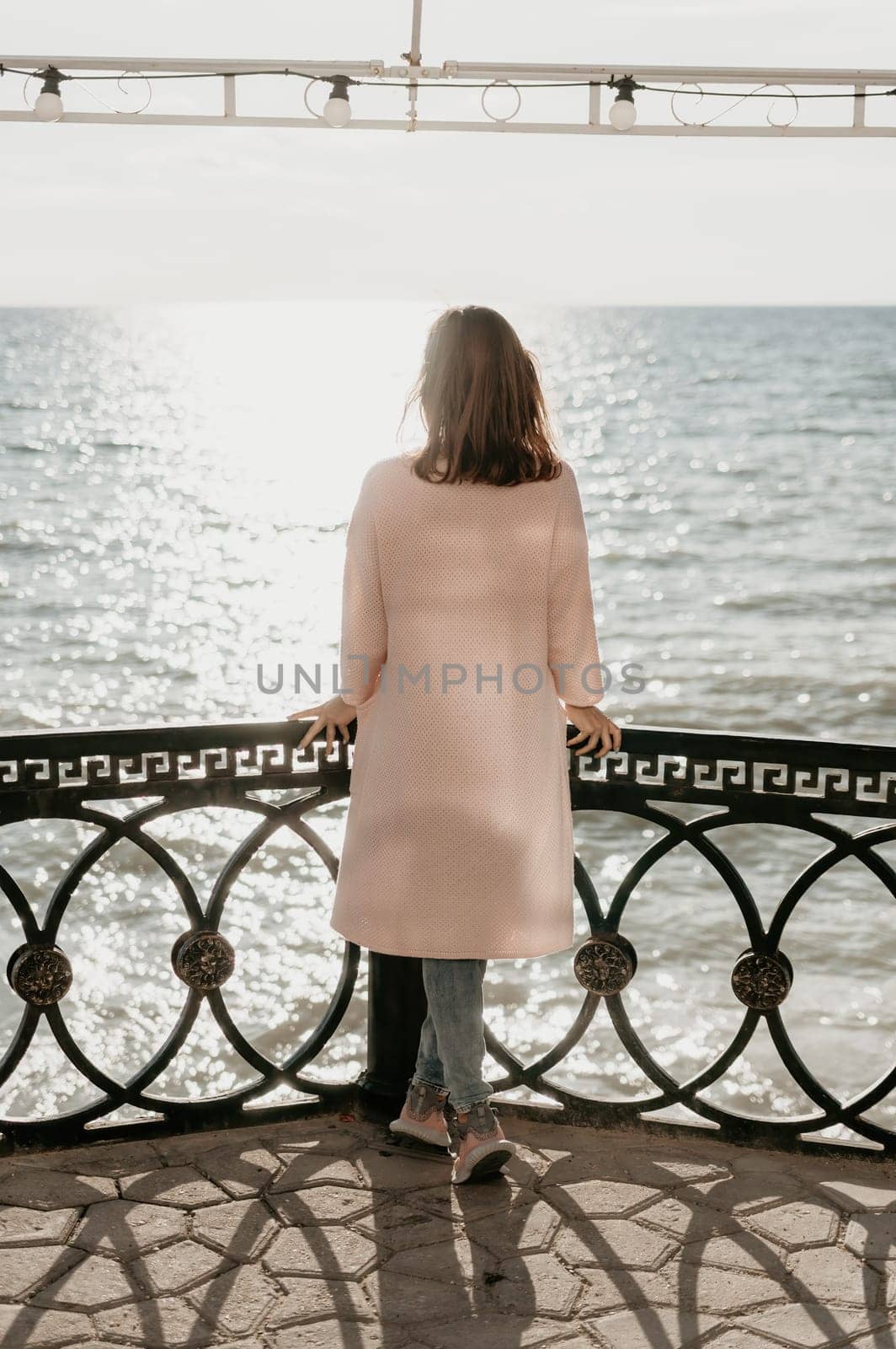 Woman summer travel sea. Happy tourist enjoy taking picture outdoors for memories. Carefree woman traveler posing on beach at sea on sunset, sharing travel adventure journey. Holiday vacation concept. by panophotograph