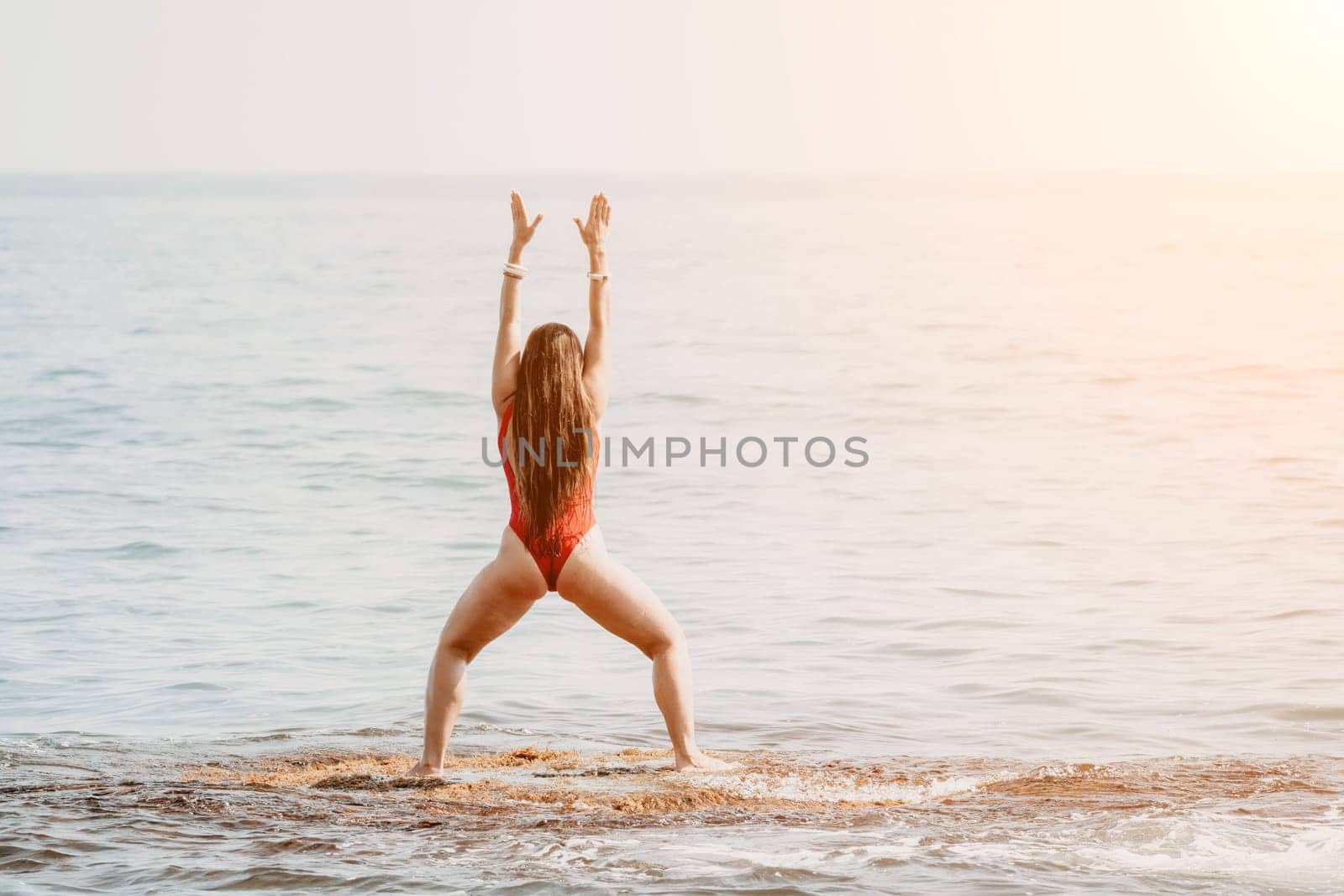 Woman sea yoga. Back view of free calm happy satisfied woman with long hair standing on top rock with yoga position against of sky by the sea. Healthy lifestyle outdoors in nature, fitness concept.