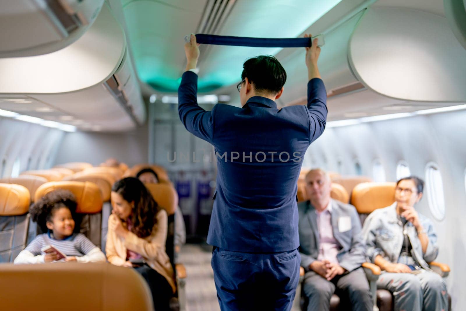 Airline staff man demonstration and explain about safety tools, safety belt, in the airplane to the passenger before the flight in airport area.