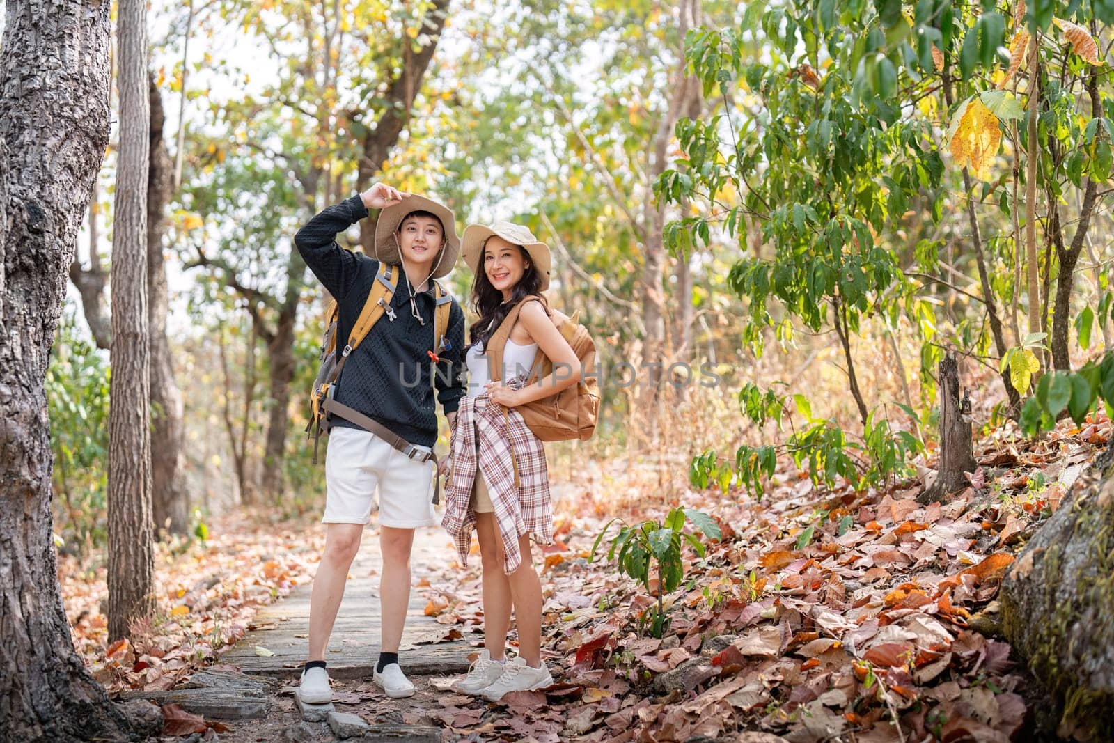 Lovely couple lesbian woman with backpack hiking in nature. Loving LGBT romantic moment in mountains.