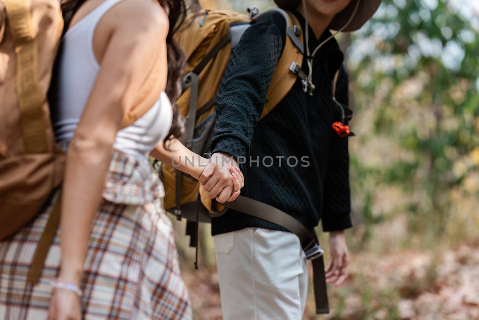 Happy LGBT Lesbian couple Travelers Hiking with Backpacks in forest Trail. LGBT Lesbian Couple Hikers with backpacks walks in mountains in vacation.