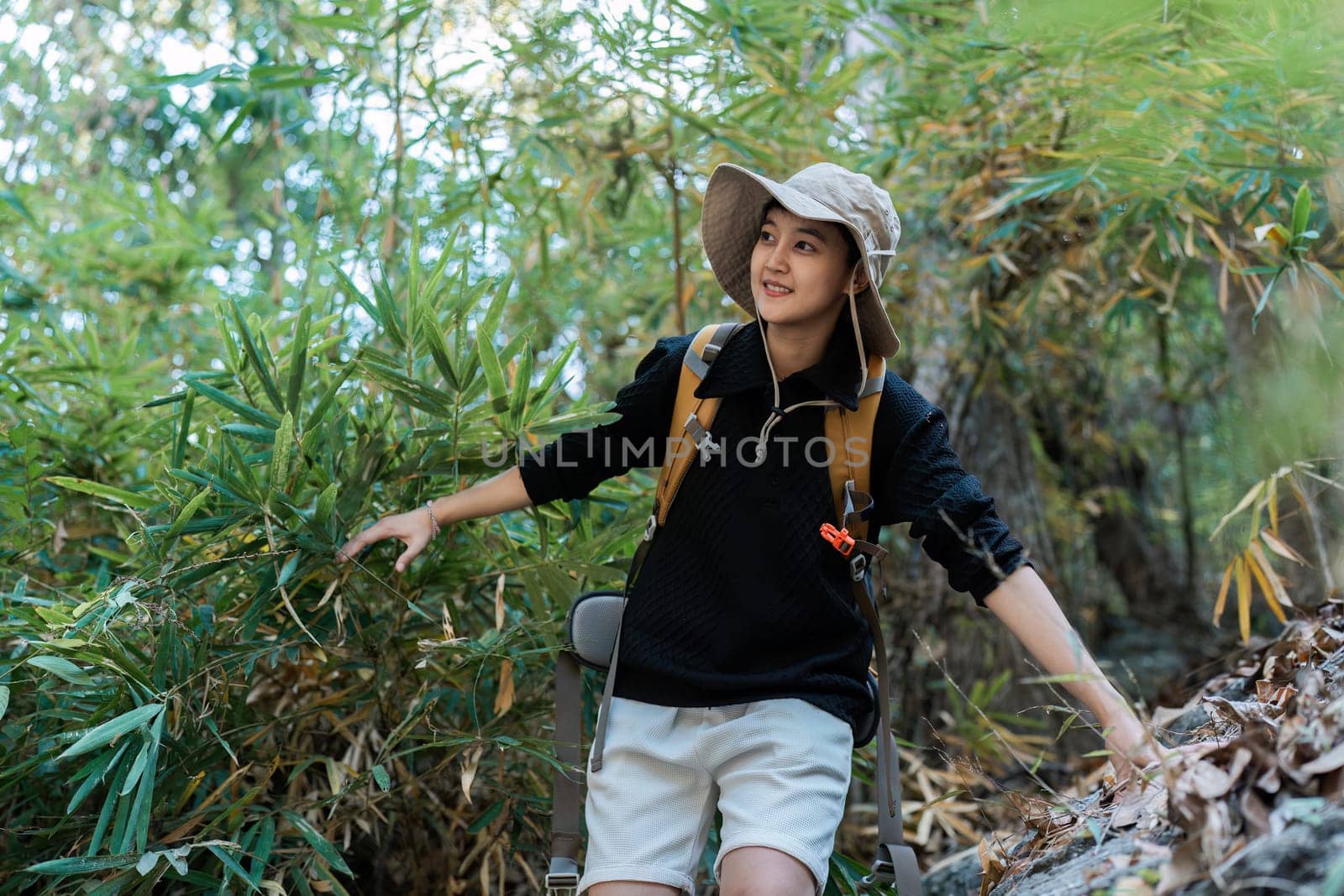 LGBTQ backpacker traveling alone in forest. Attractive male traveler walking in nature wood during holiday vacation trip.