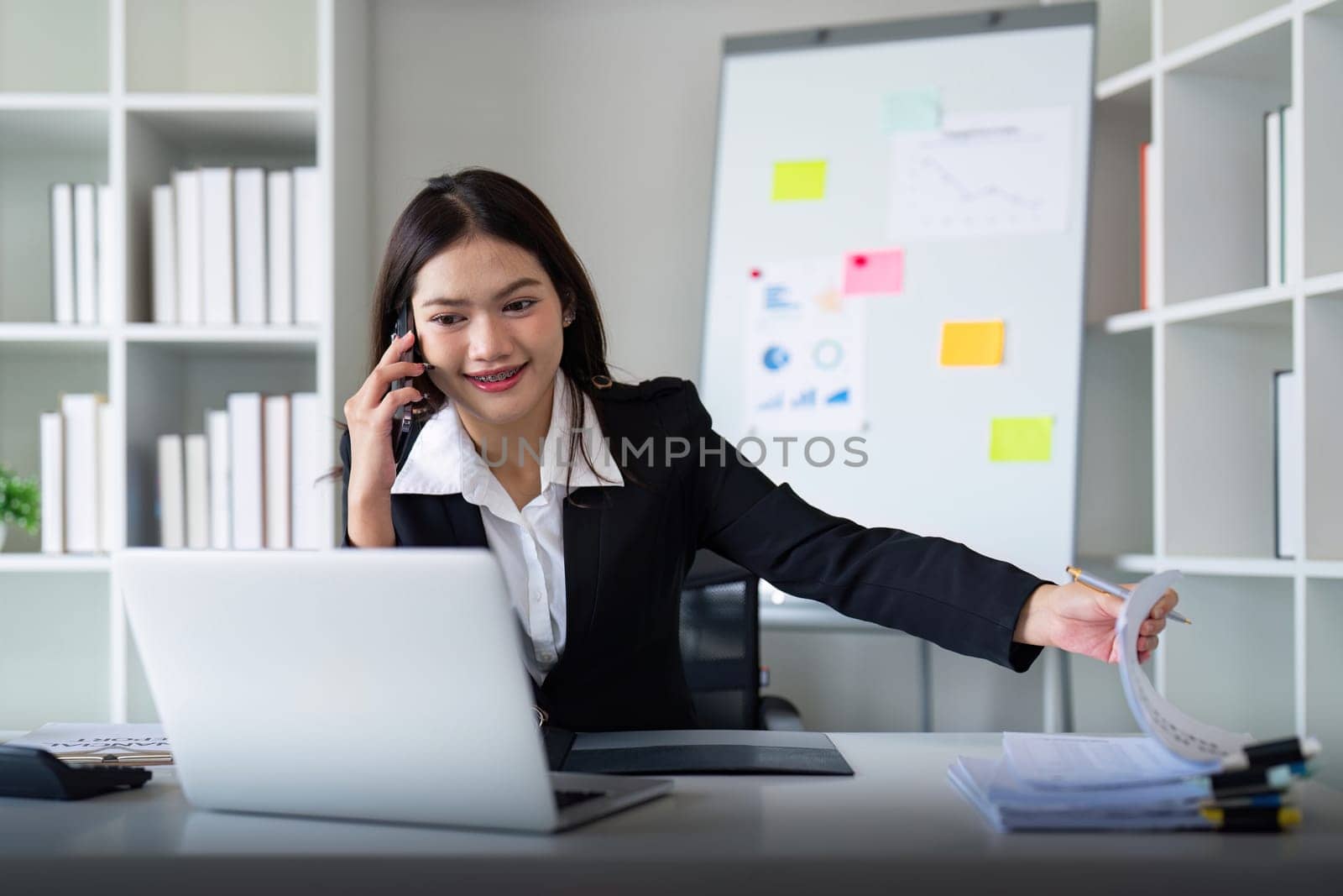 Happy confident businesswoman talking on the phone. Smiling female business person talking work using talking on the phone at office sitting at desk by nateemee