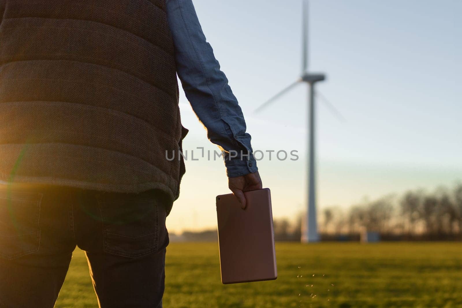 Businessman checking on wind turbine energy production.