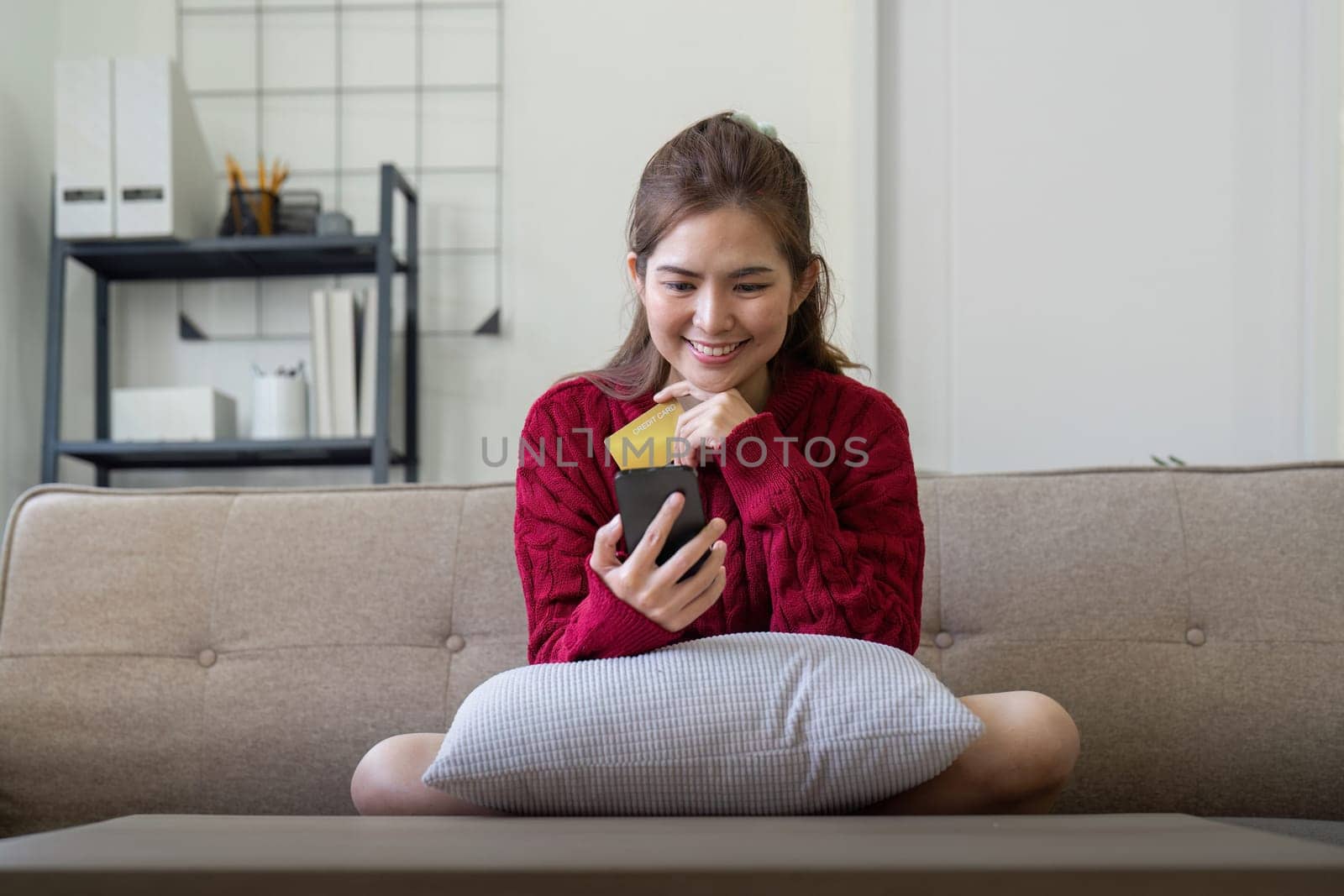 Young Asian woman hands holding credit card and using smartphone for internet purchase. Online shopping, Online payment at home by nateemee