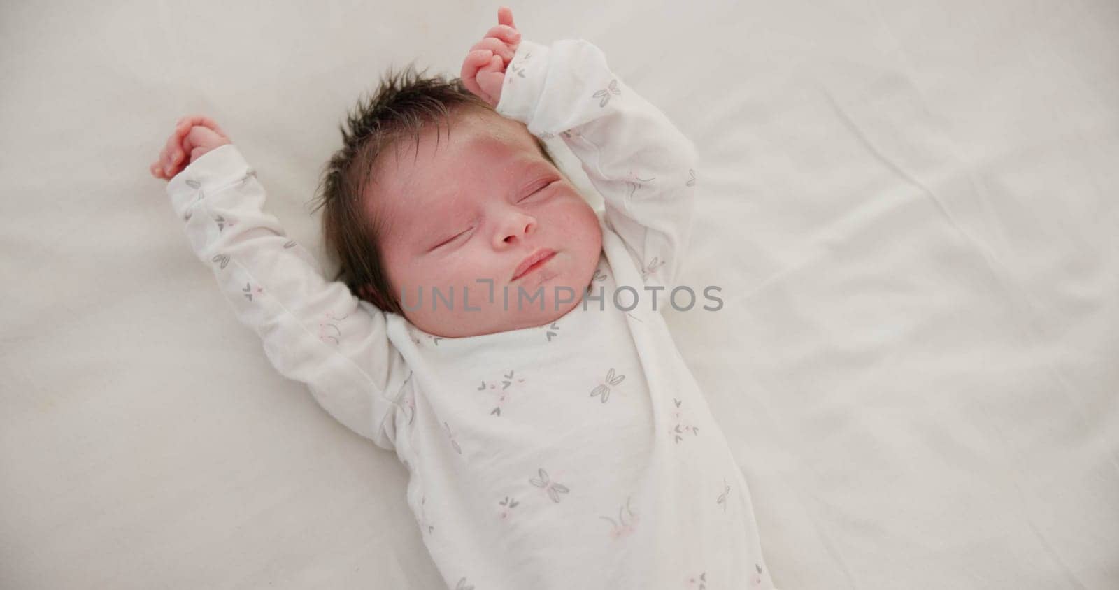 Newborn, face or sleeping with stretching on bed in nursery for relaxing or resting with child development. Baby, tired or dreaming in bedroom of house with calm, relax and cute infant in family home.