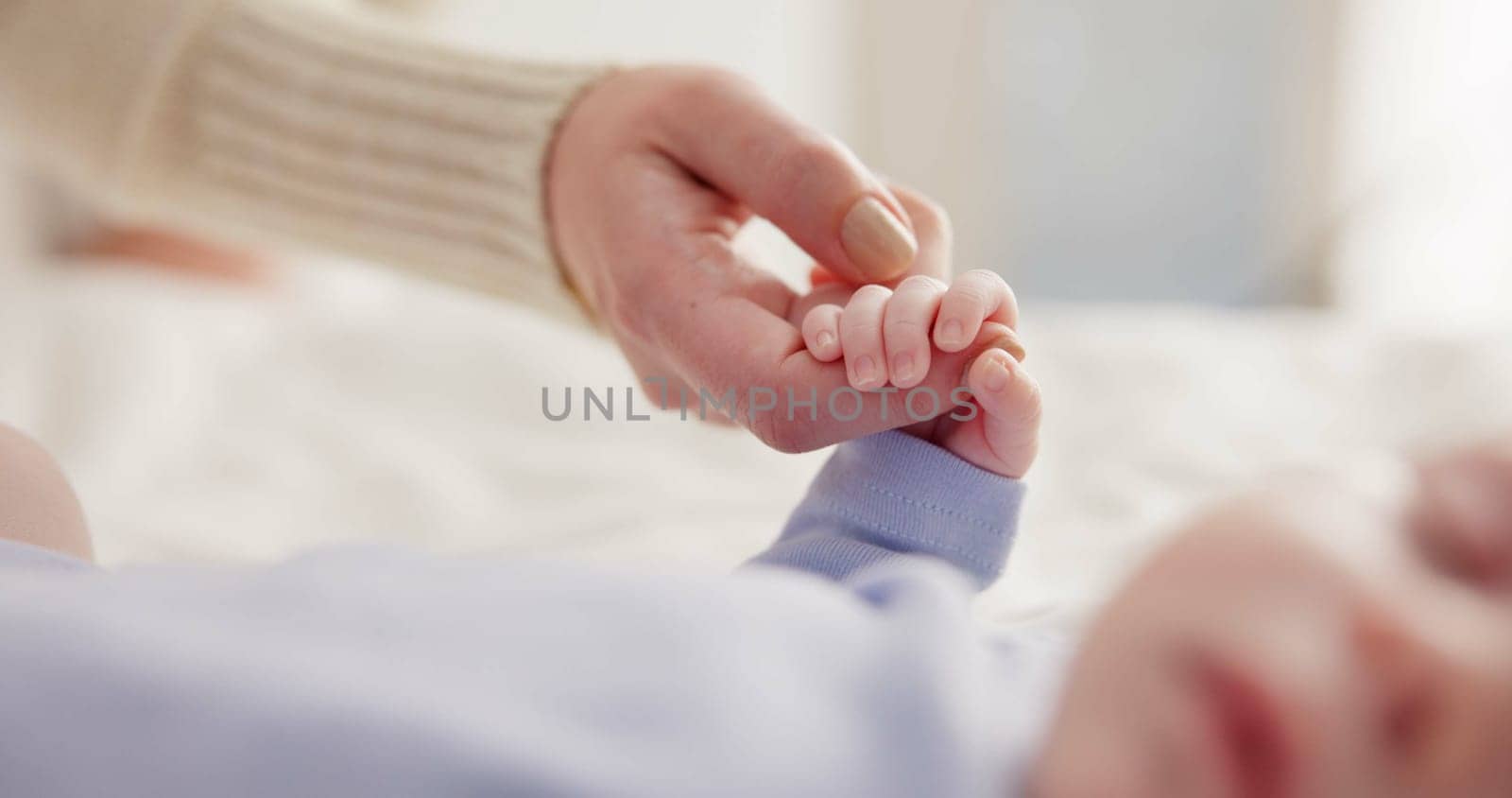 Parents, family and holding hands with baby on bed for bonding, love and relationship with infant. Adorable, cute and closeup of mom with hand of newborn for support, wellness and protection at home.