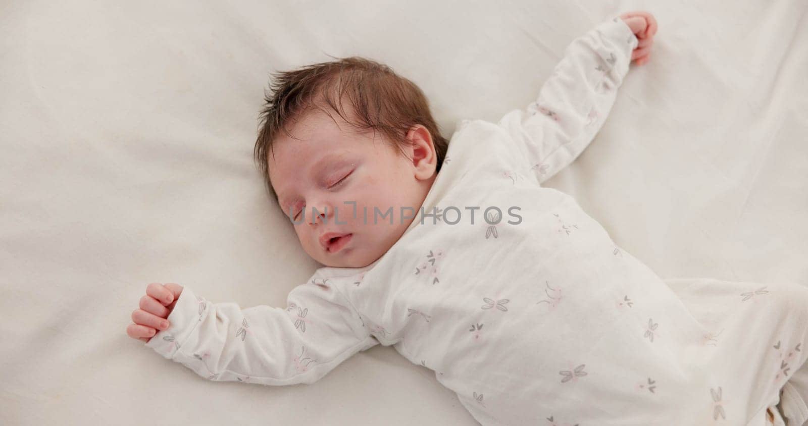 Cute, sleeping and newborn baby on a bed at a home in the bedroom for resting and dreaming. Tired, sweet and top view of infant, child or kid taking a nap in the morning in nursery at family house. by YuriArcurs