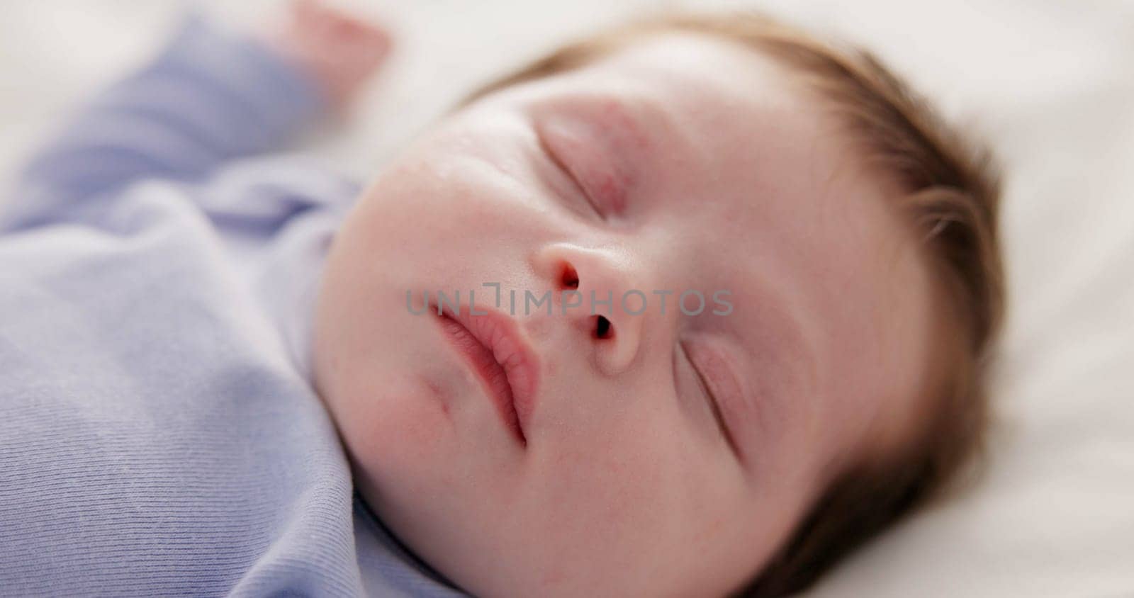 Face, growth and sleep with a baby on a bed closeup in a home, dreaming during a nap for child development. Relax, calm and rest with an adorable newborn infant asleep in a bedroom for comfort.