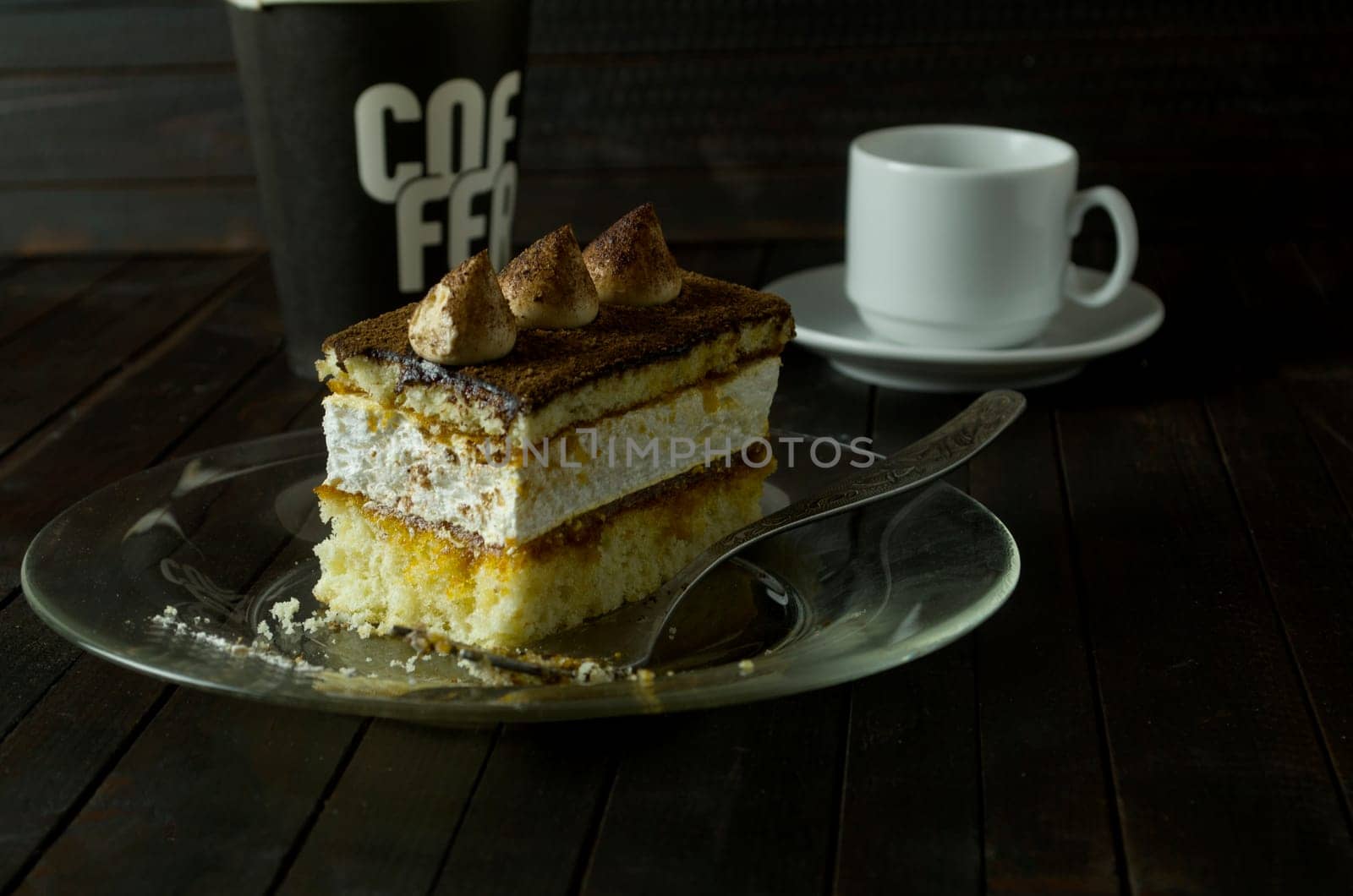 a piece of Truffle cake on glass plate on dark wooden table.