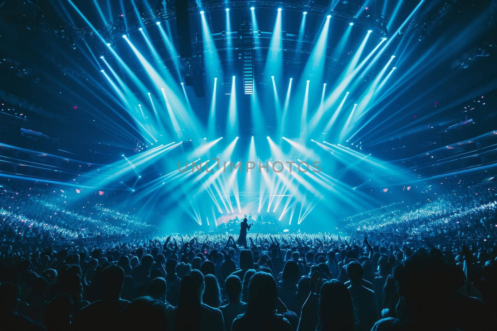 Singer performs a musical concert on stage in a huge packed stadium hall. Epic lights and flashlights