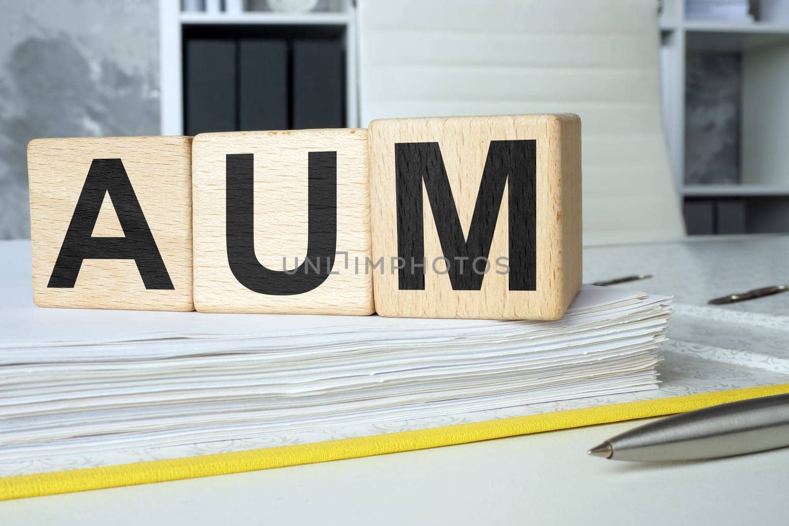 An open folder and cubes on it. AUM assets under management. by designer491
