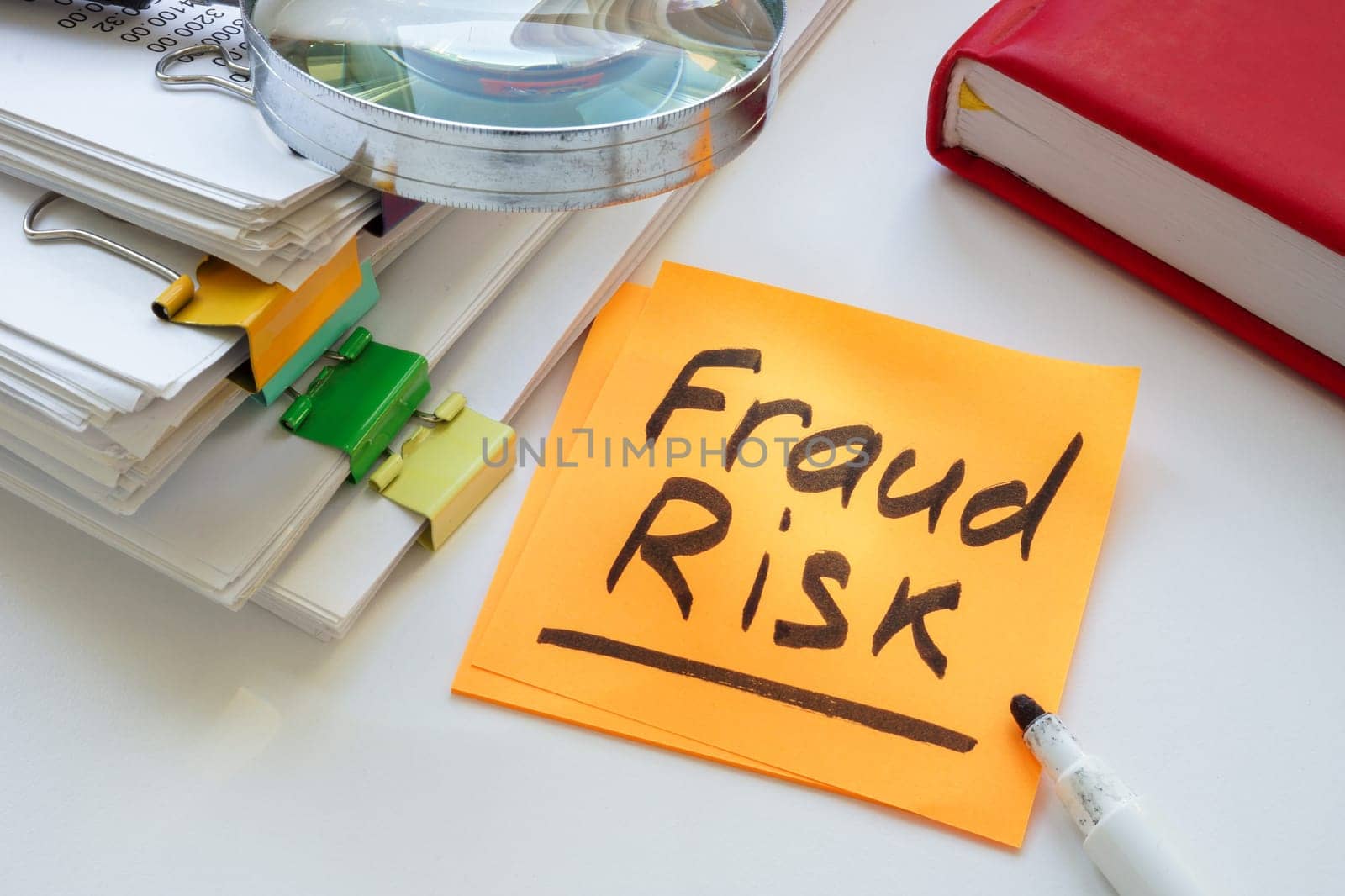 Fraud risk inscription and stack of papers. by designer491