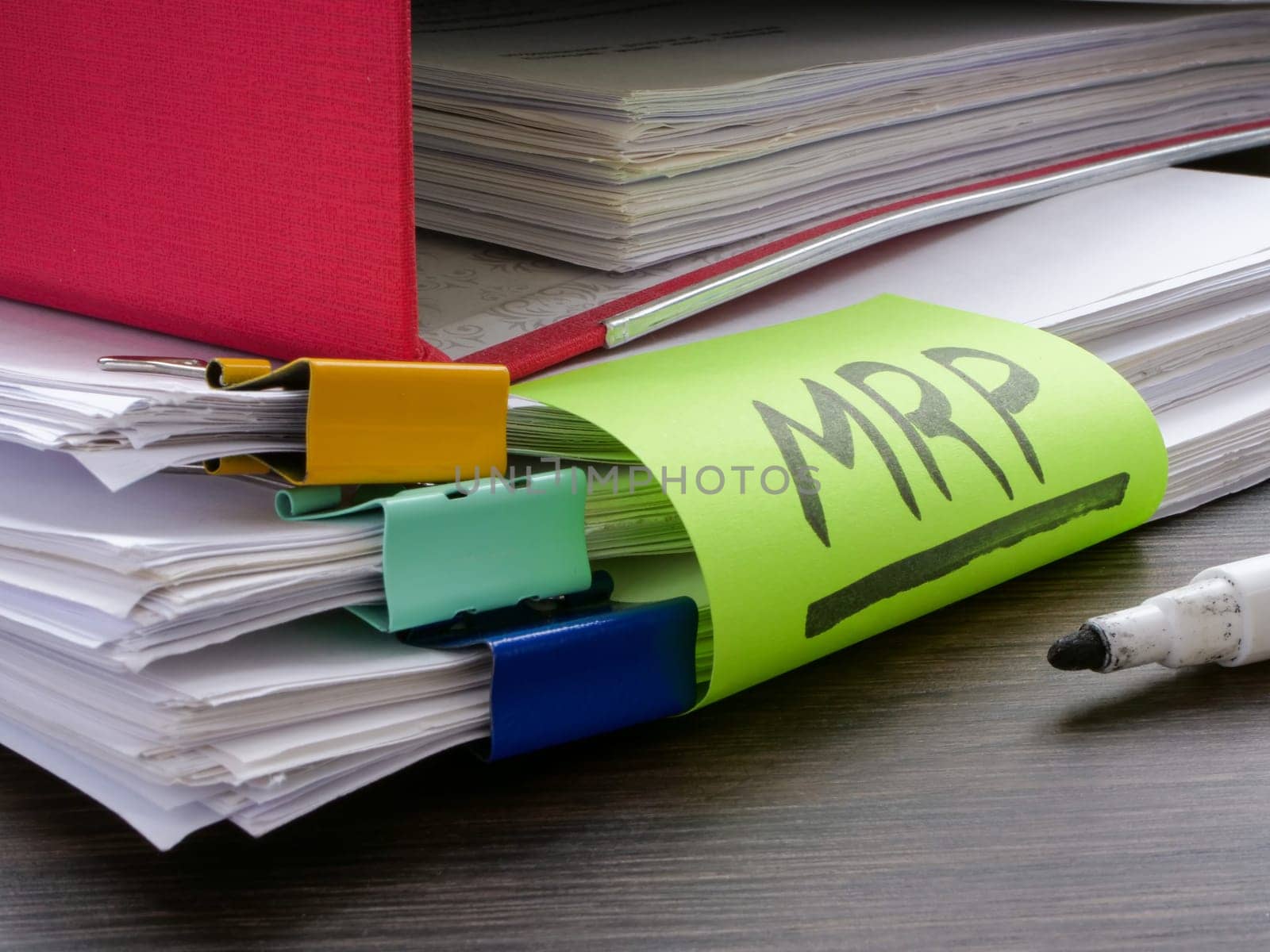 Stack of papers and label MRP Material requirements planning. by designer491