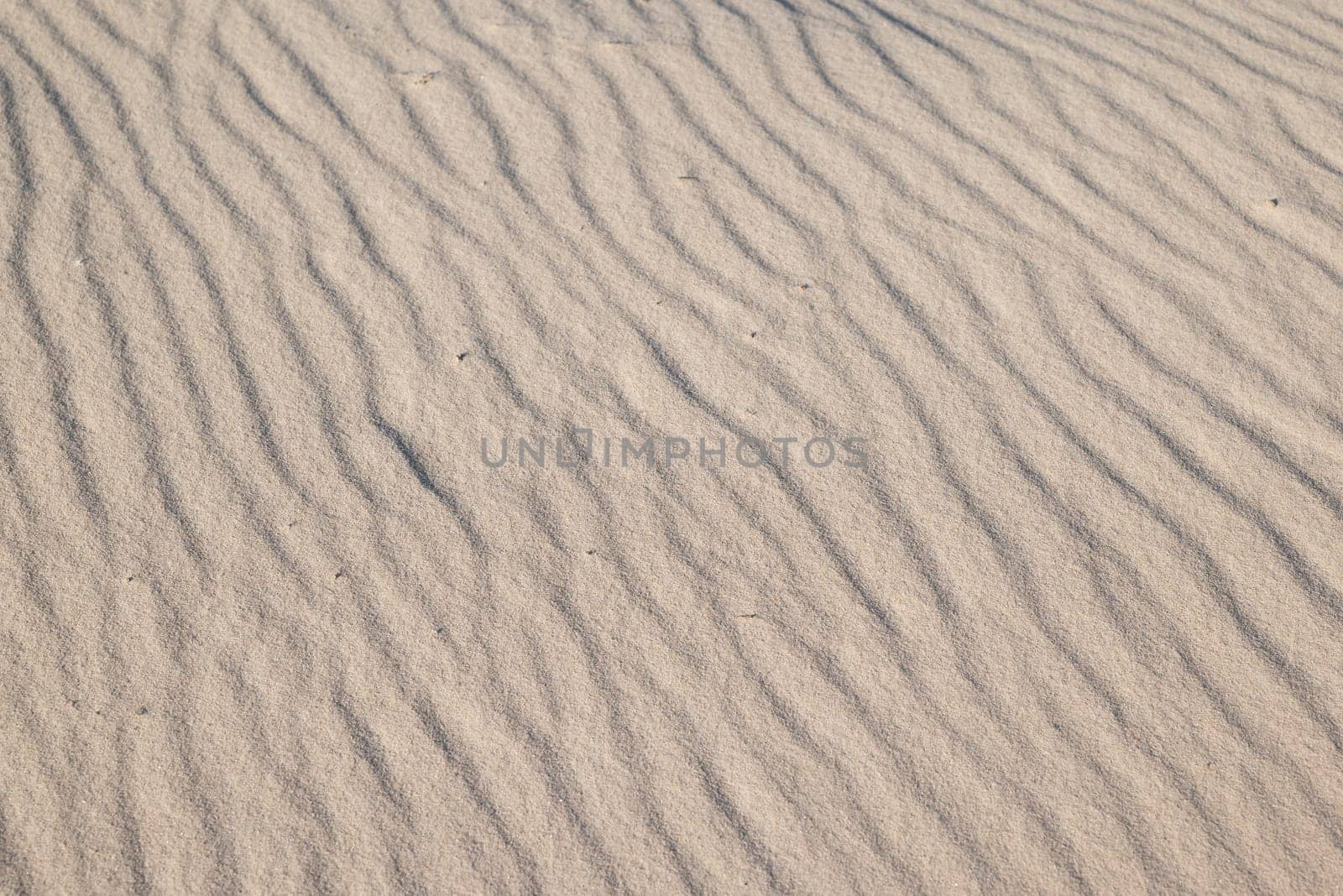 Close up of wavy sand texture on the coast by VitaliiPetrushenko