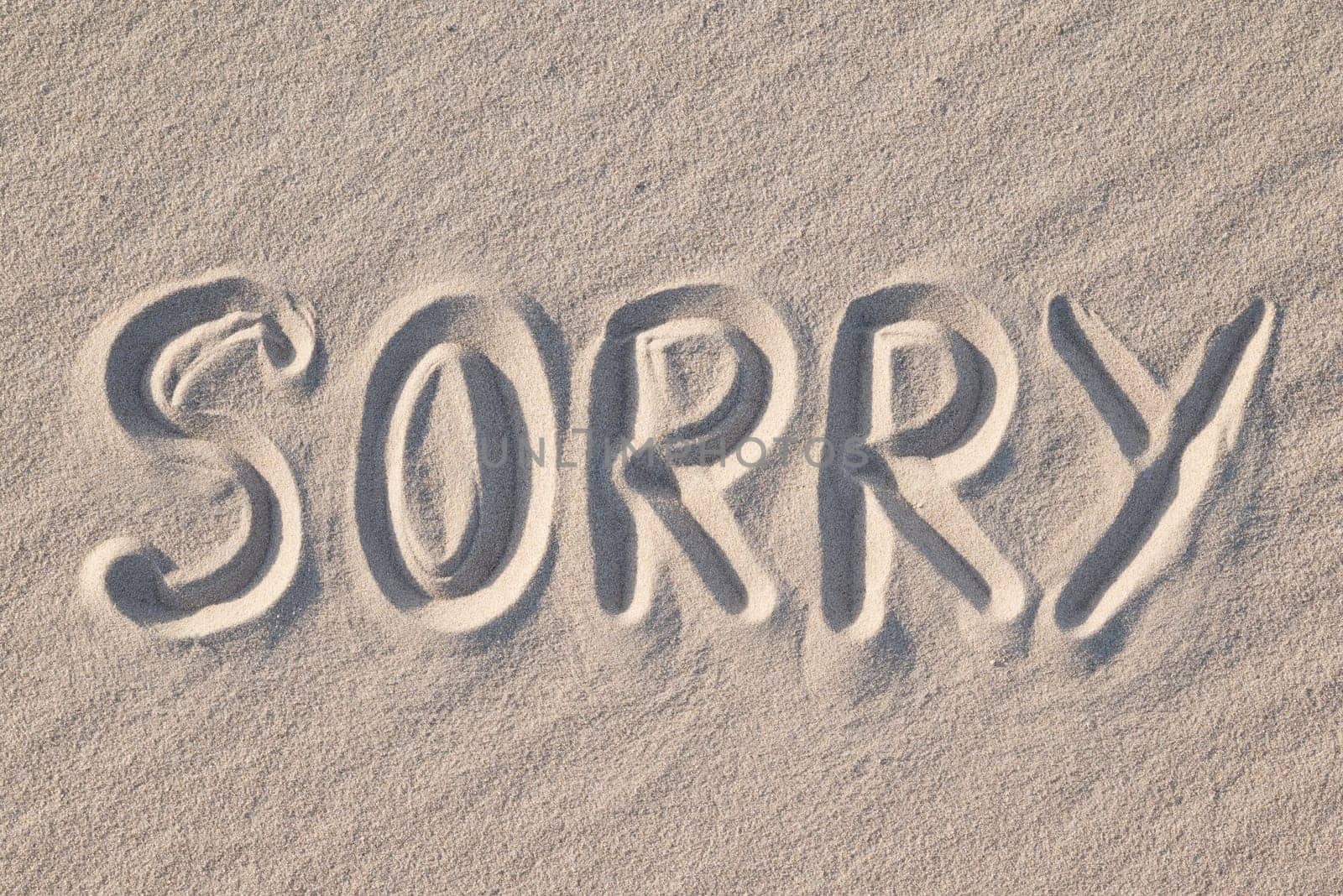 Word Sorry written on sand, close up by VitaliiPetrushenko