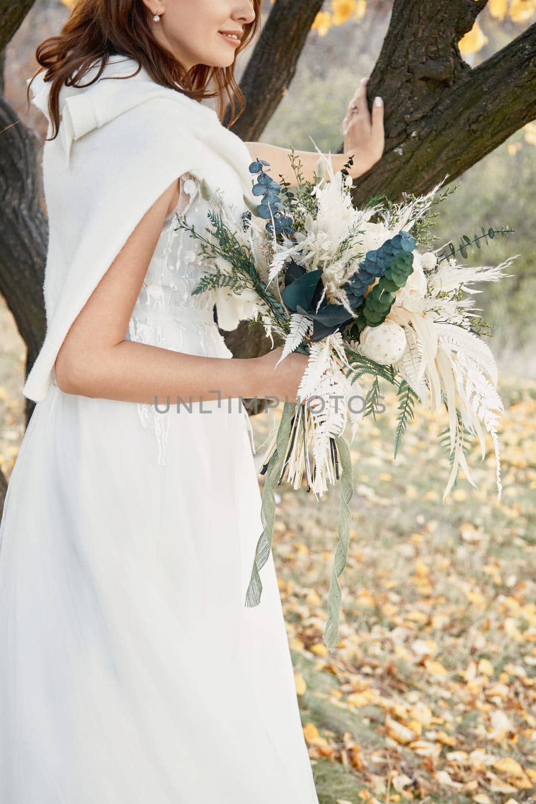 hands of the bride holding beautiful bouquet by erstudio