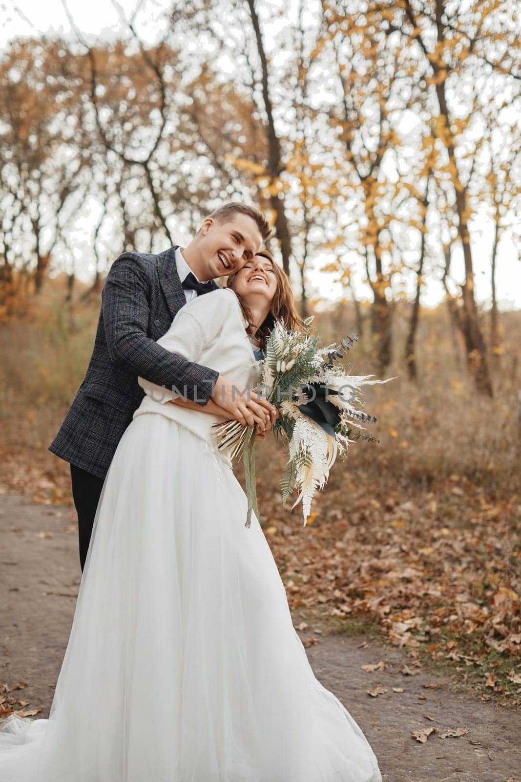 smiling bride and groom enjoying romantic moments outside in autumn