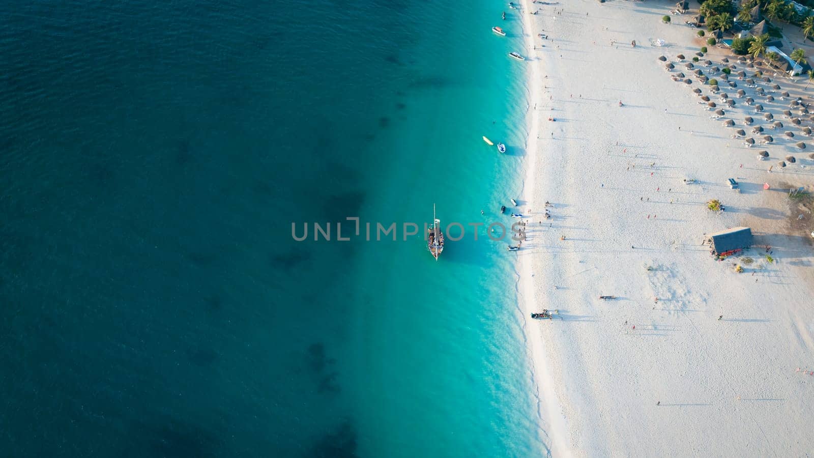Drone view of dhow boat in the green ocean and wonderful white sandy beach by Robertobinetti70