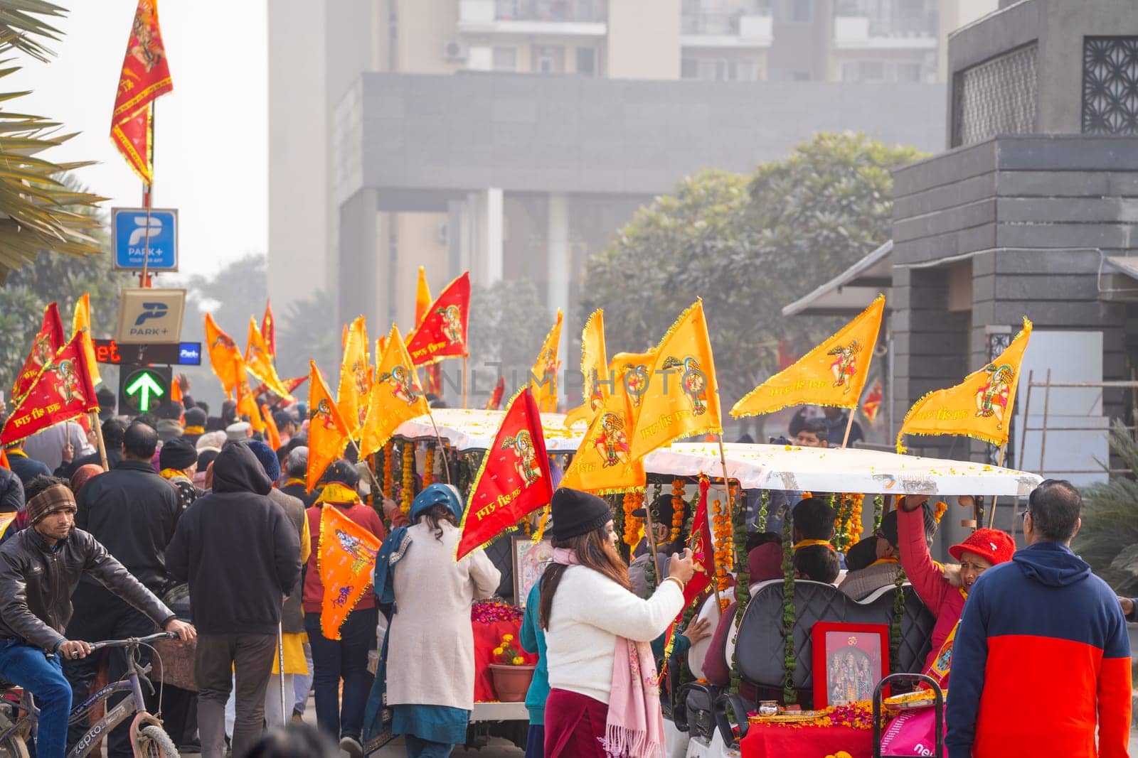 Huge crowd of hindu devotees walking along holding flag celebrating the Pran Pratishtha consecration of Ram mandir temple massive celebration in India by Shalinimathur