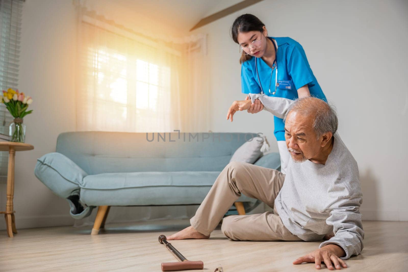 Asian older senior man falling down on lying floor and woman nurse came to help support by Sorapop
