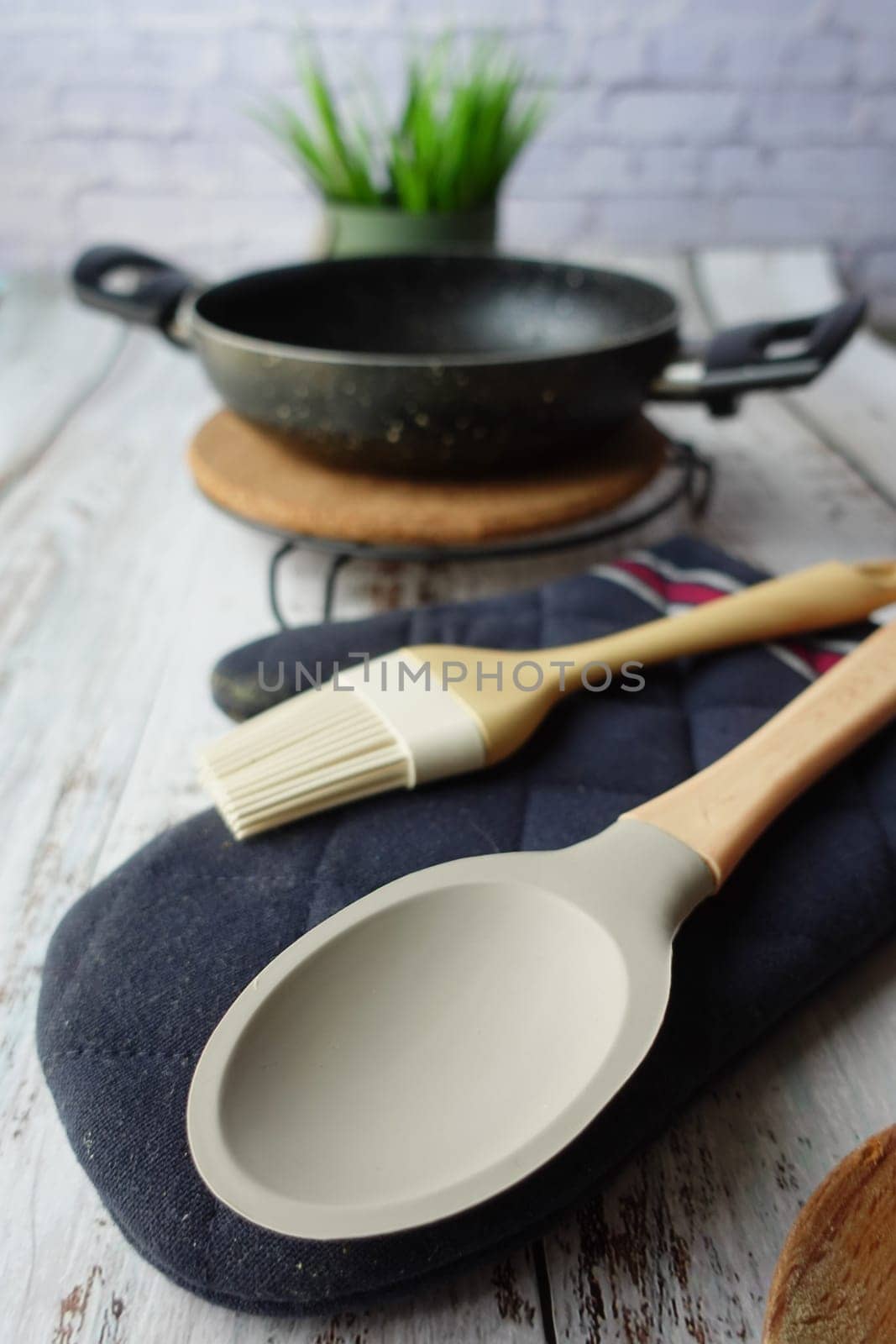 wooden cutlery fork and spoon and cooking pan on table .