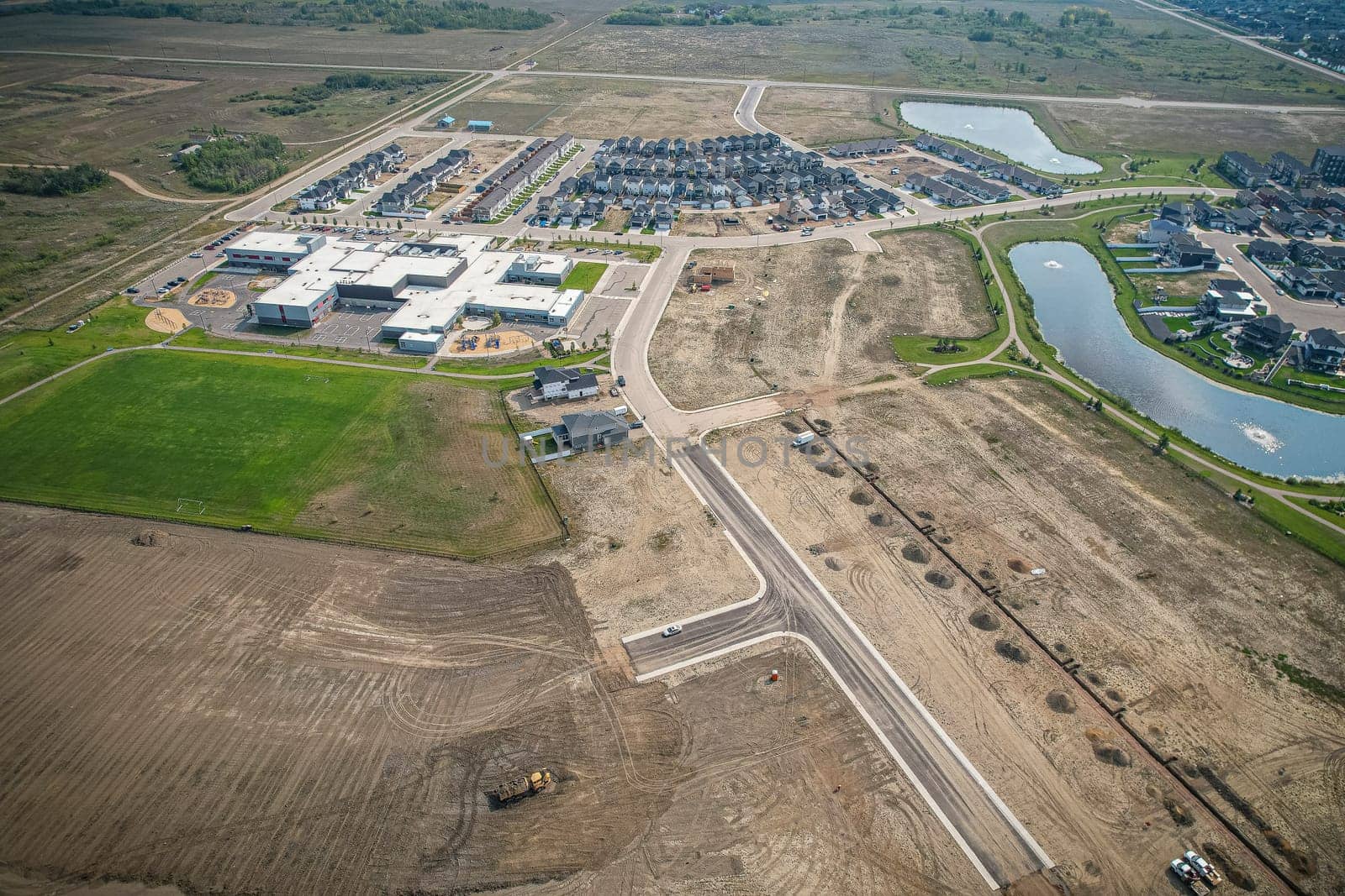 Drone image capturing the town of Martensville in Saskatchewan during the summer season, highlighting its suburban and residential areas surrounded by lush greenery