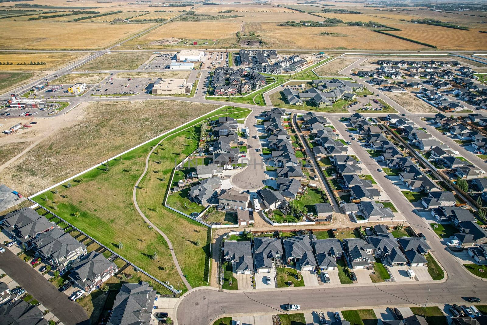 Drone image capturing the town of Warman in Saskatchewan during the summer season, highlighting its suburban and residential areas surrounded by lush greenery and vibrant atmosphere