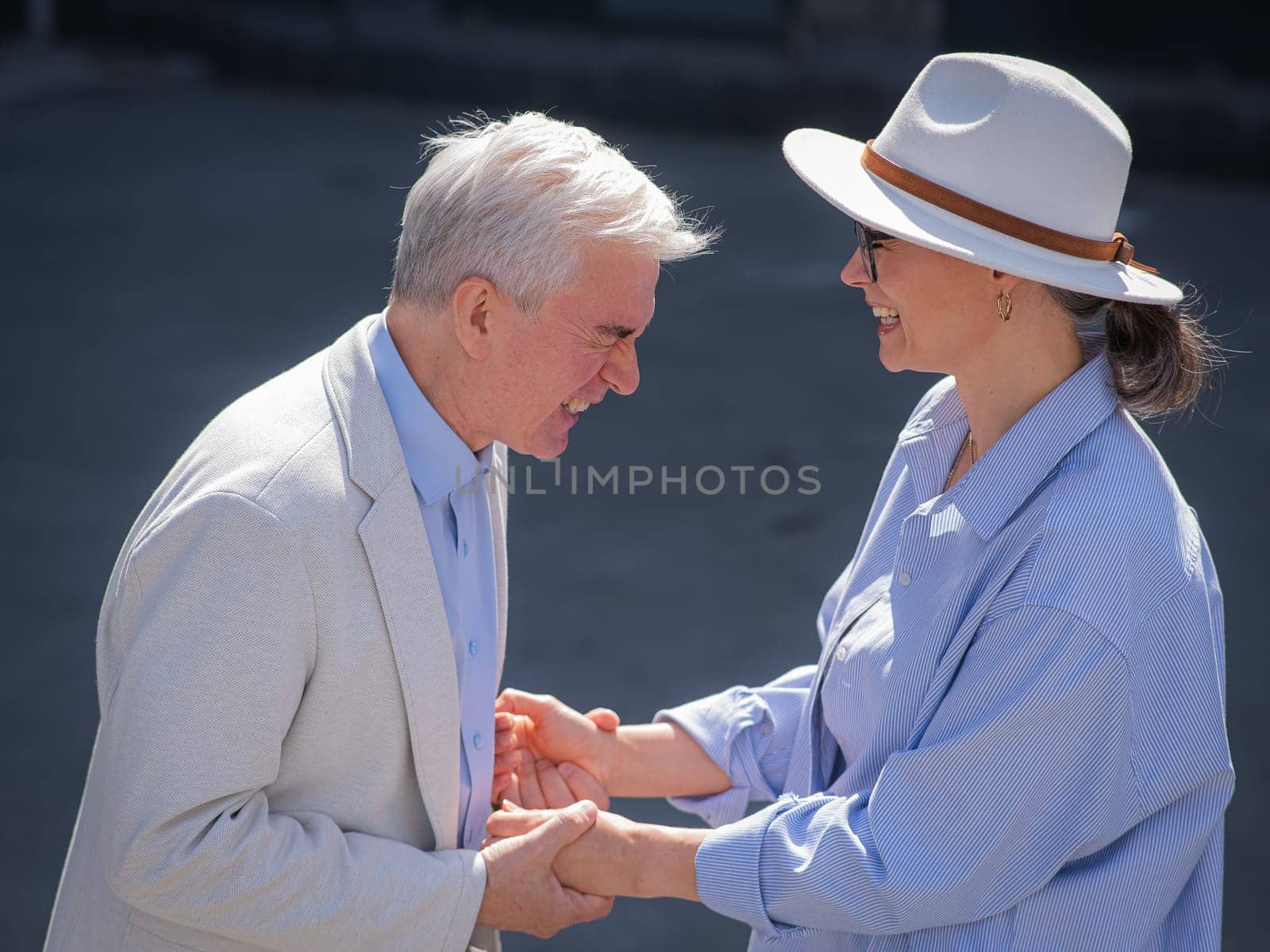 Stylish elderly laughing couple on a walk. Romantic relationships of mature people. by mrwed54