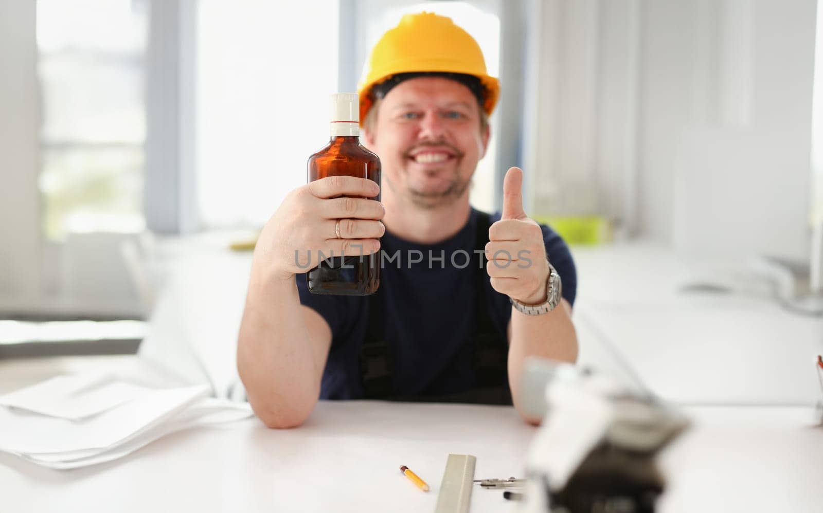 Arm of drunken worker in yellow helmet show OK gesture or confirm sign with thumb up closeup. Manual job workplace DIY inspiration fix shop hard hat industrial education profession career