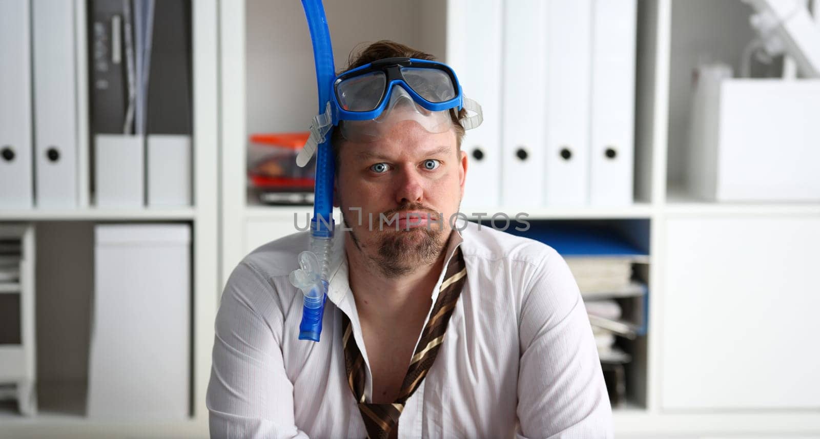 Man wearing suit and tie in goggles with snorkel sit at office workplace ready to take off portrait. Count days to leave annual day off workaholic freedom fun tourism resort idea concept