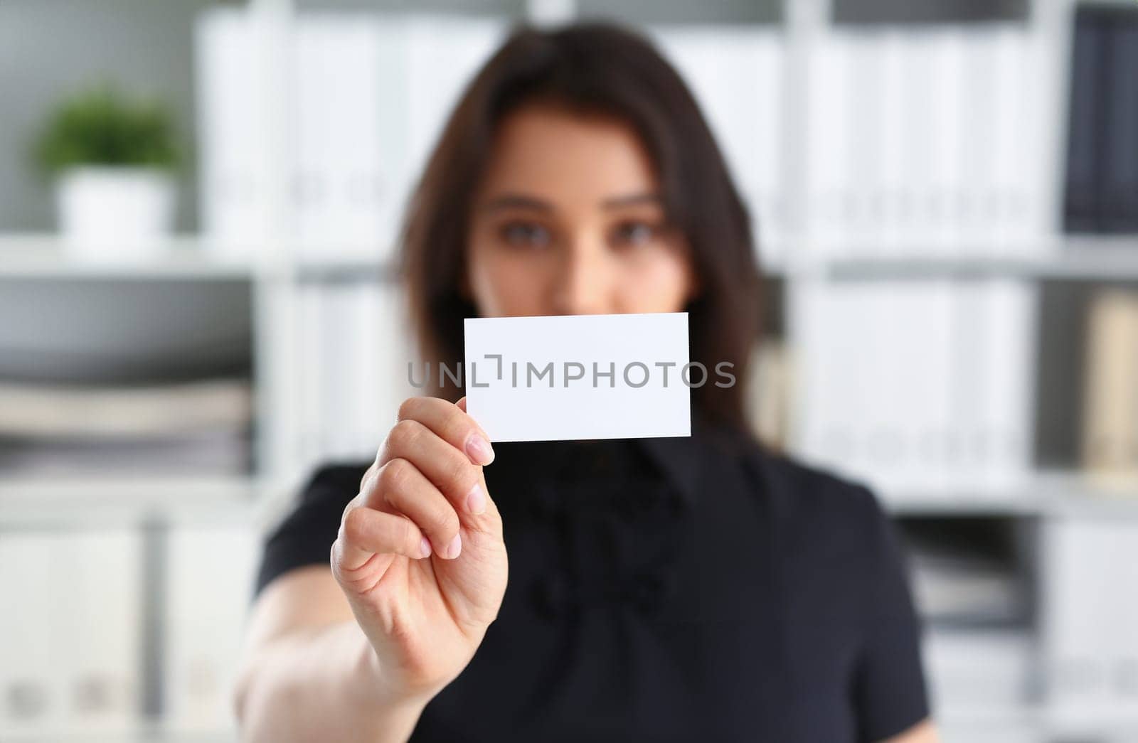 portrait of young beautiful brunette chinese businesswoman work in office show cutaway business card