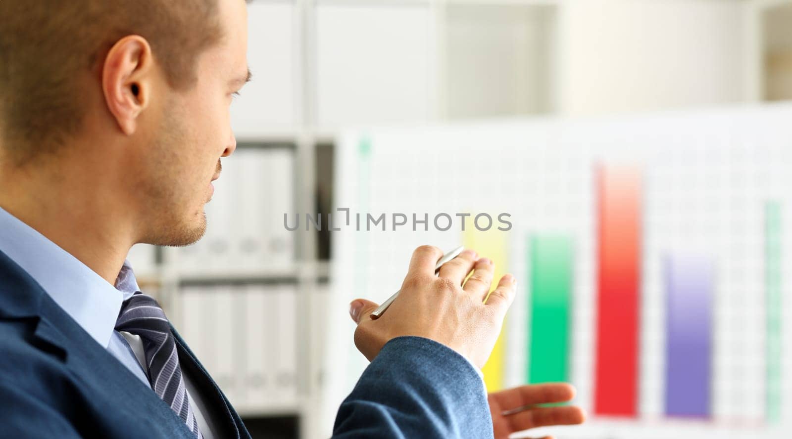 Man in suit point with arm in stats graph in office closeup. Stock exchange market advisor sale examination industry profit research occupation account career present ambition negotiation study trade