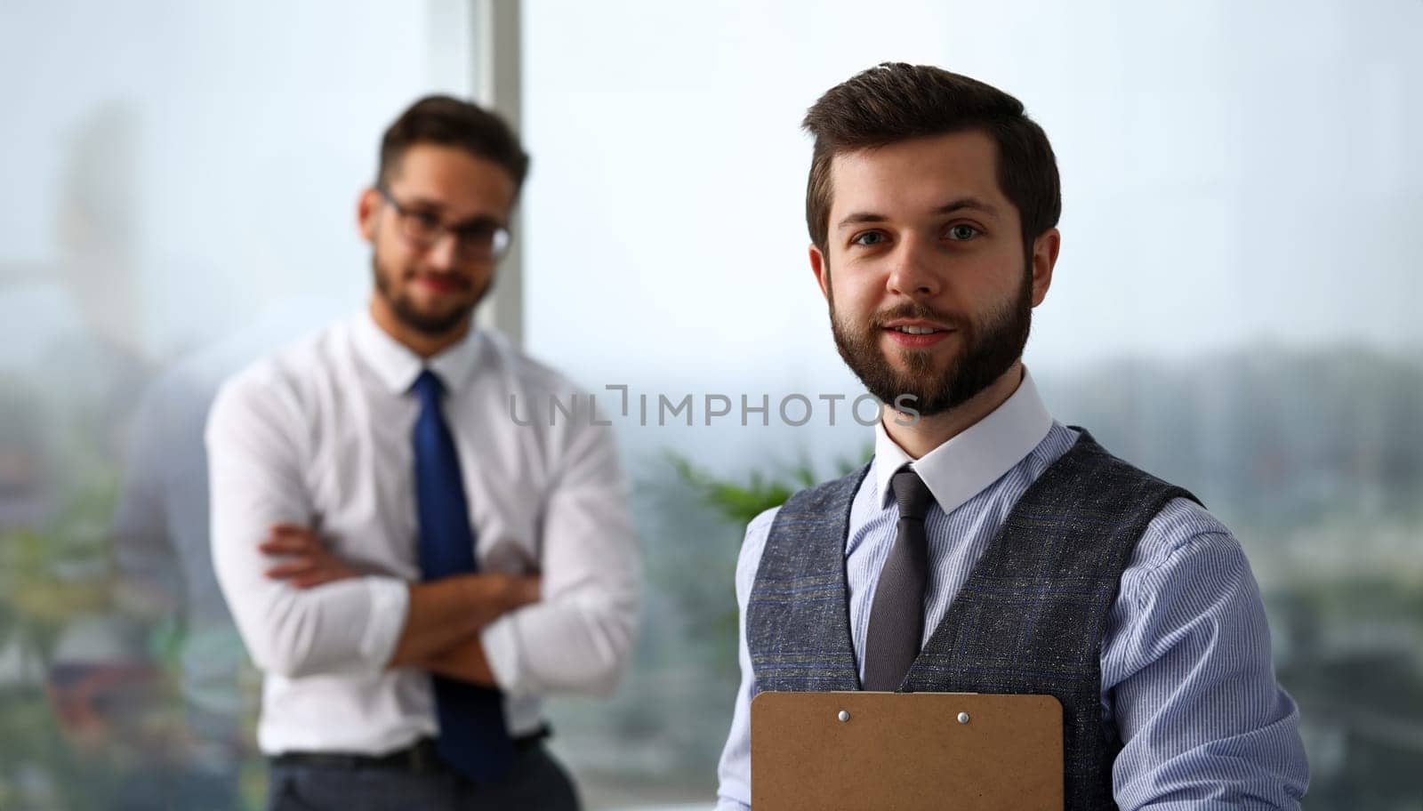 Handsome smiling bearded clerk man at workplace look in camera by kuprevich