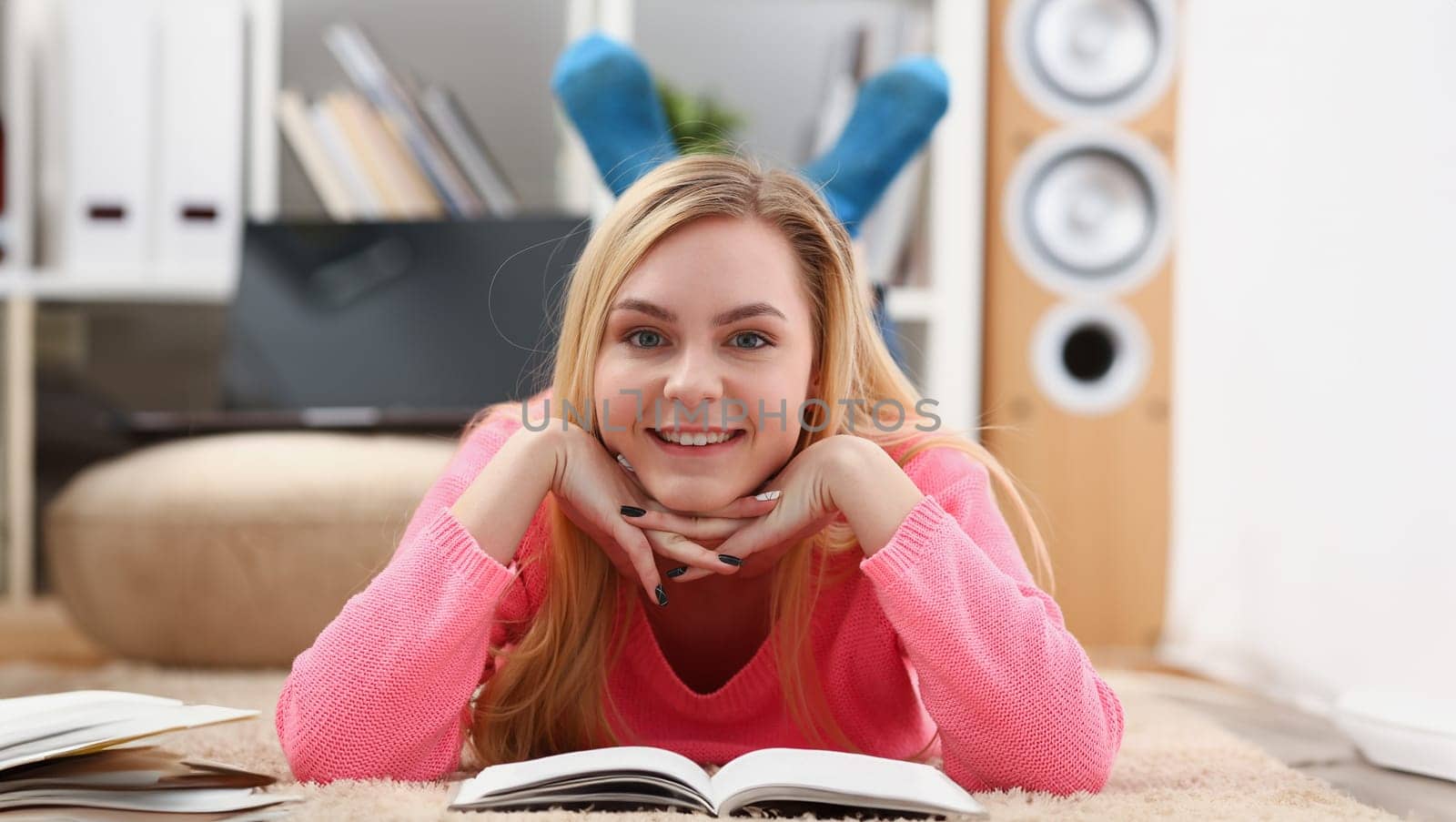 young beautiful blond woman lie on the floor read book enjoy study concept