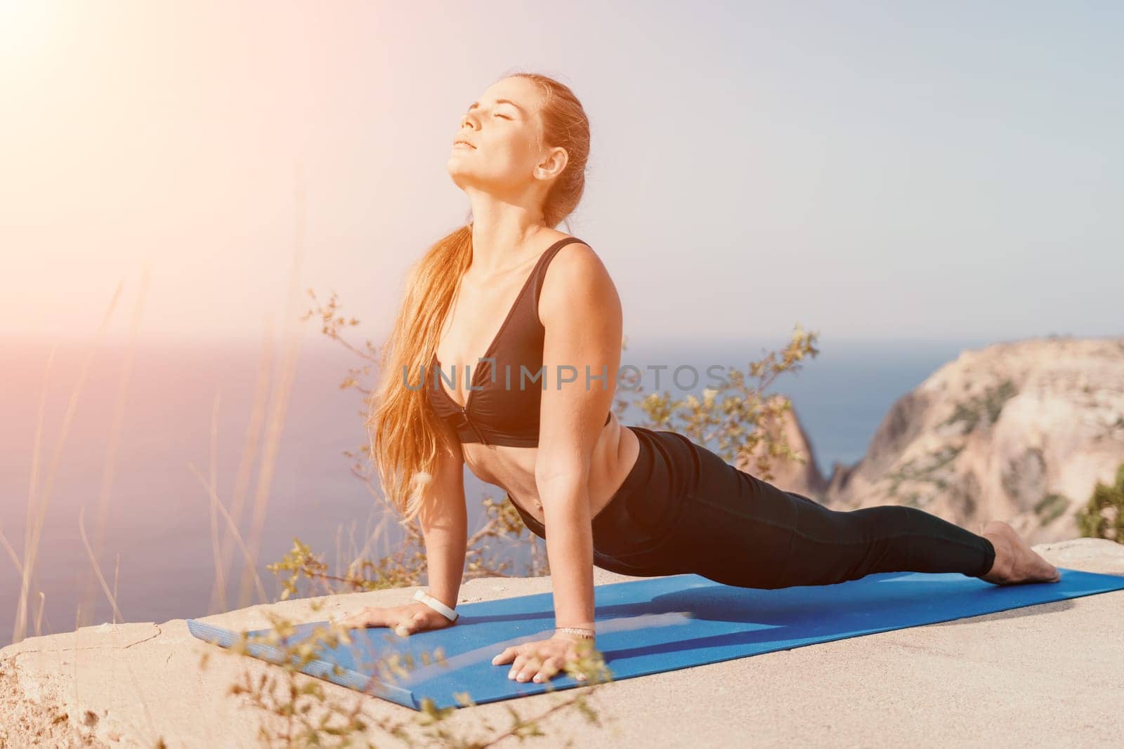 Fitness woman sea. Outdoor workout on yoga mat roller in park near to ocean beach. Female fitness pilates yoga routine concept. Healthy lifestyle. Happy fit woman exercising with rubber band in park. by panophotograph