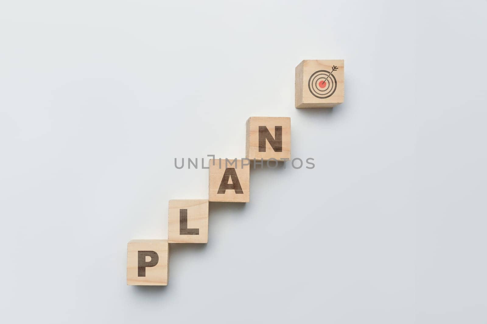 Wooden cube blocks with PLAN word with Target icon on white background. Business action plan, goals and strategy concept by prathanchorruangsak