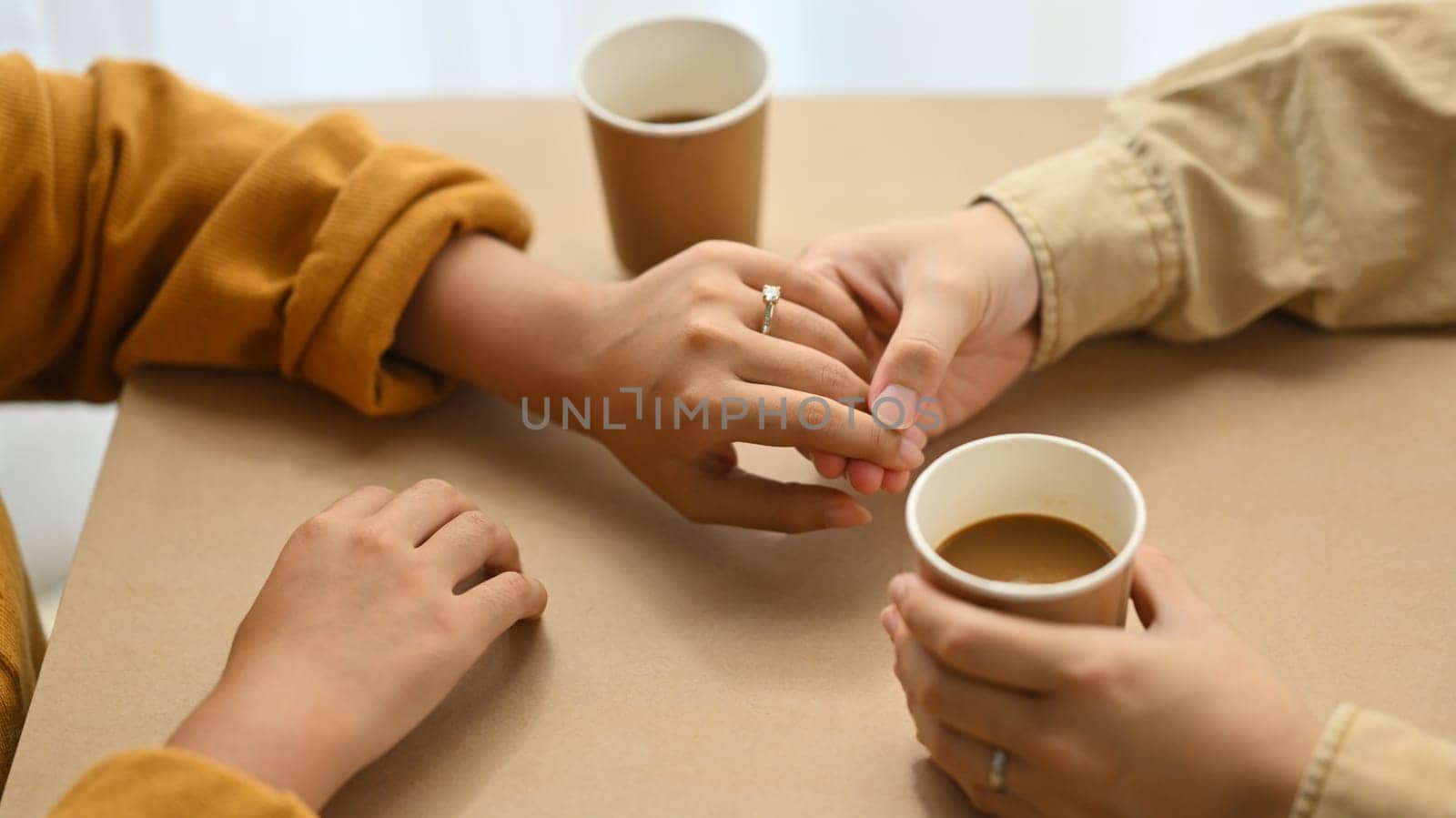 Romantic married couple holding hands on date in cafe. Love, relationship, togetherness and lifestyle concept by prathanchorruangsak