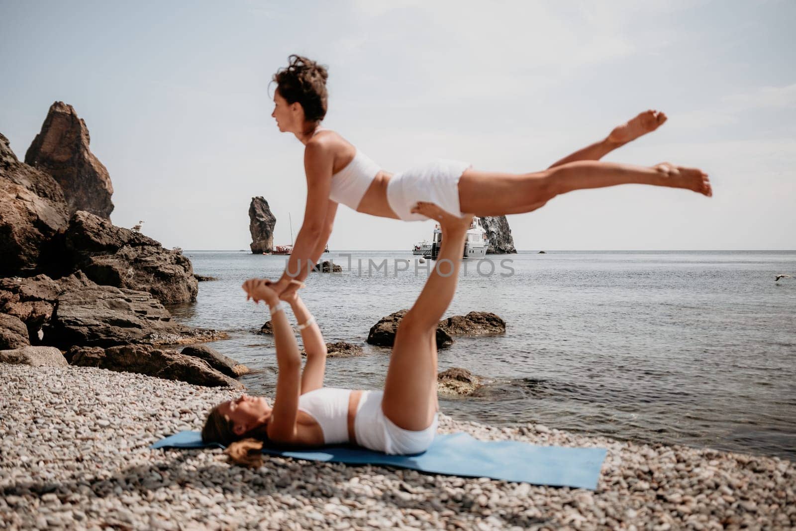 Woman sea yoga. Back view of free calm happy satisfied woman with long hair standing on top rock with yoga position against of sky by the sea. Healthy lifestyle outdoors in nature, fitness concept.