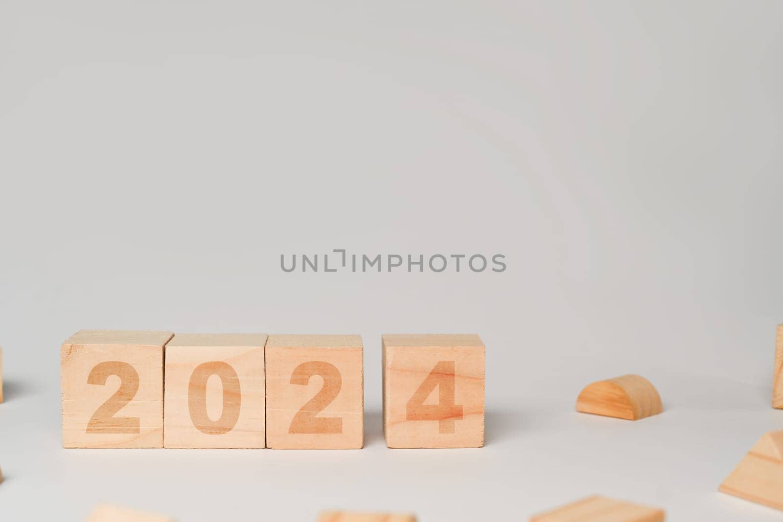 Wooden cube blocks with 2024 text on white background. Start new year and business vision concept by prathanchorruangsak