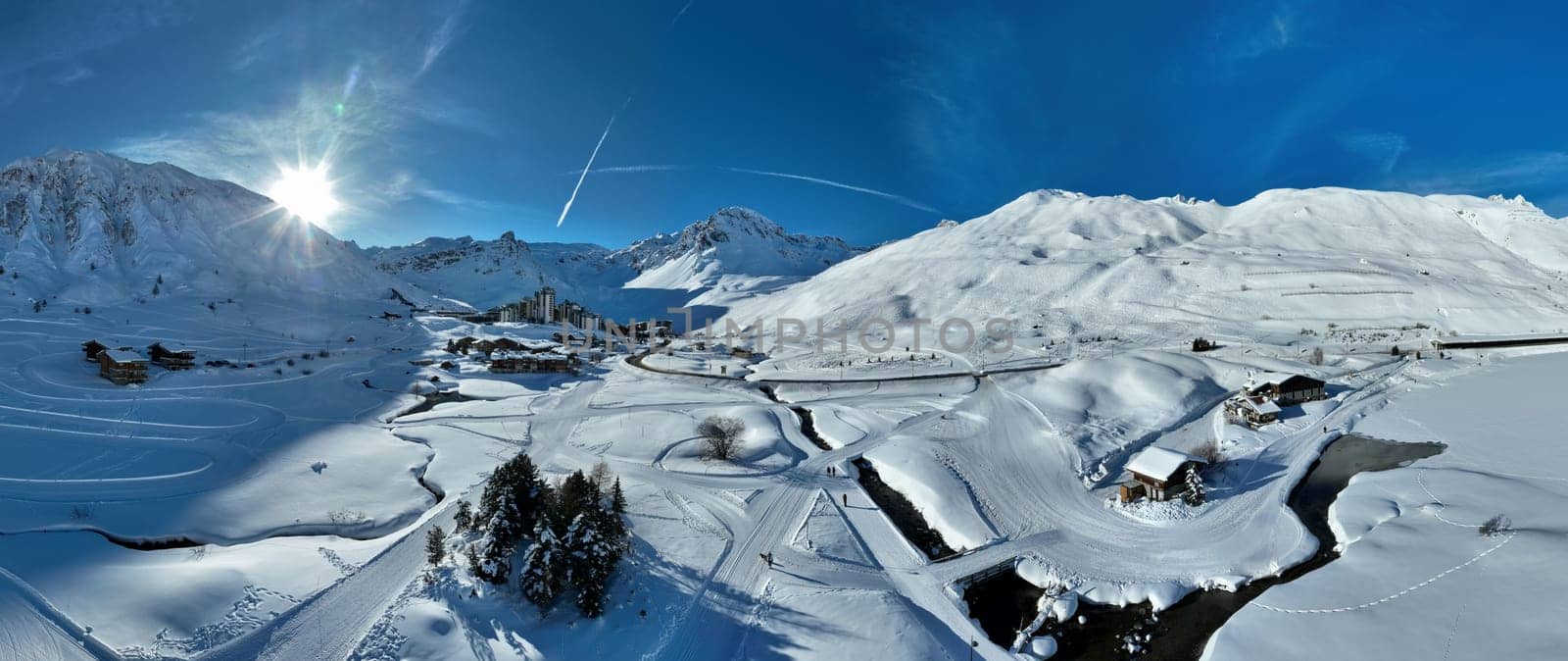 Winter drone shot of ski pistes and slopes covered with fresh powder snow in Tignes in Valdisere France. Alps aerial panoramic view on a beautiful sunny day ski lift snowboarding and skiing in resort